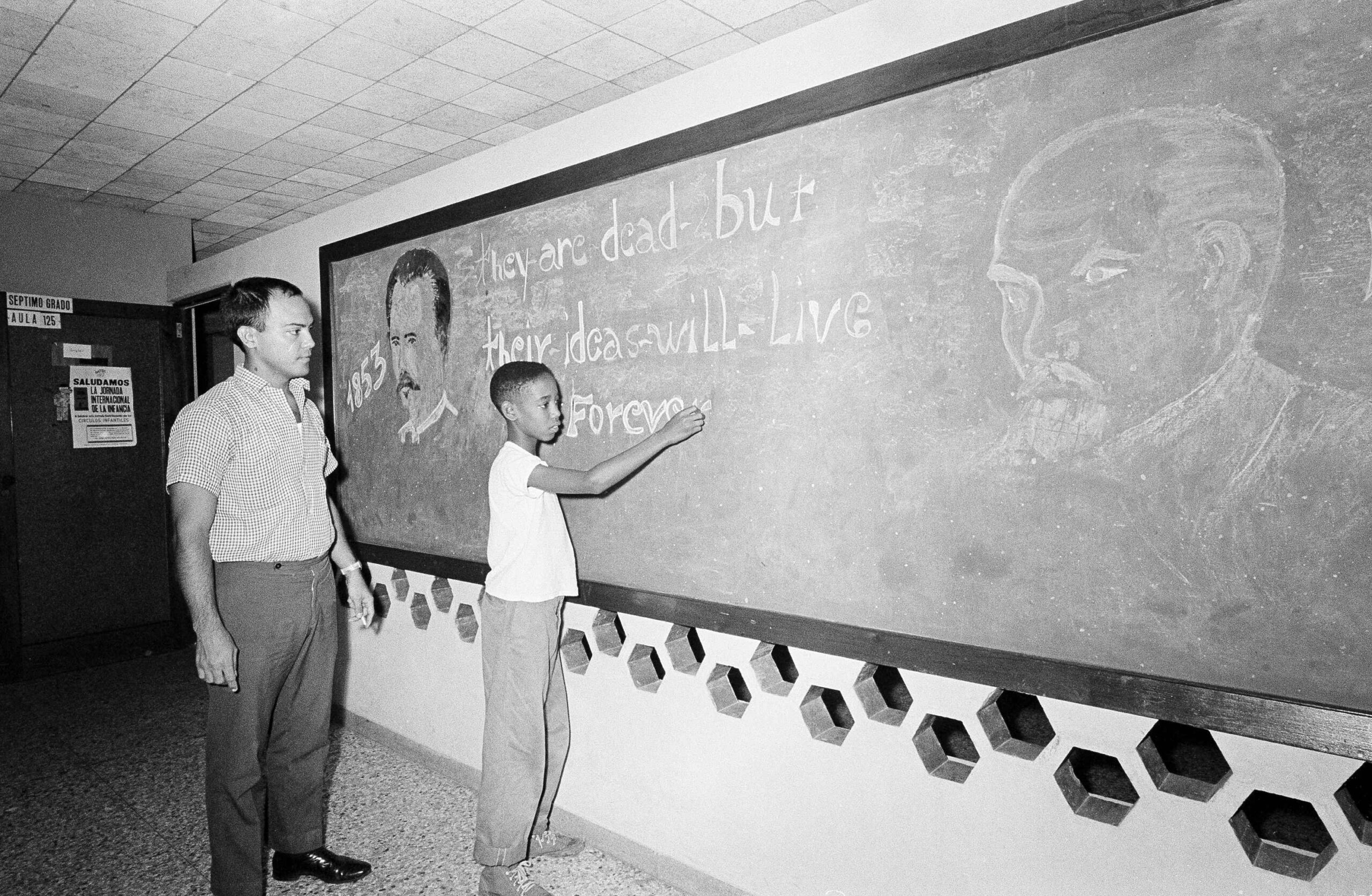 A student and teacher work on a chalkboard