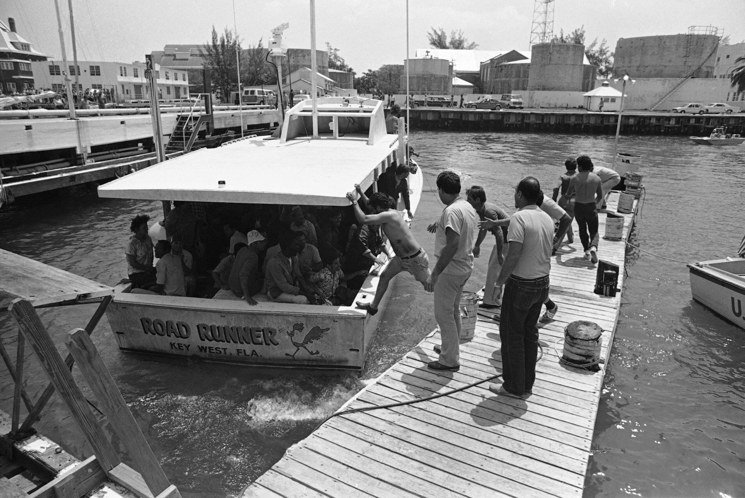 Volunteers from the Cuban exile community help pull into a dock