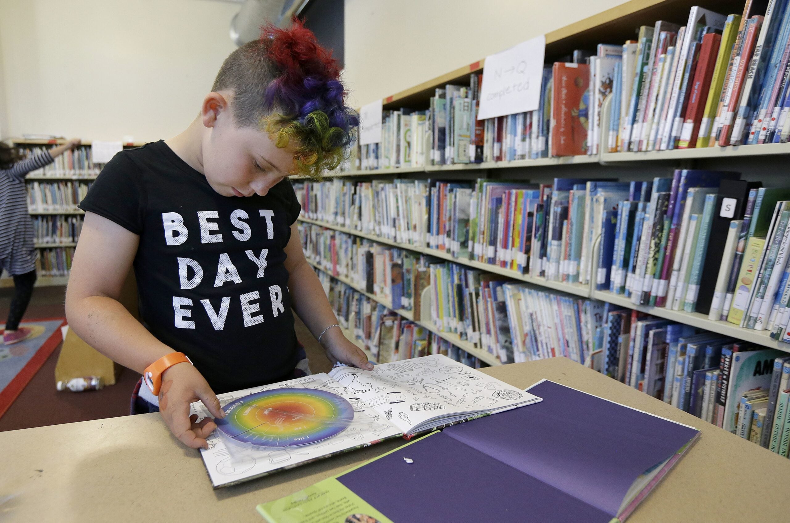 Sam, 9, reads a book in the library.