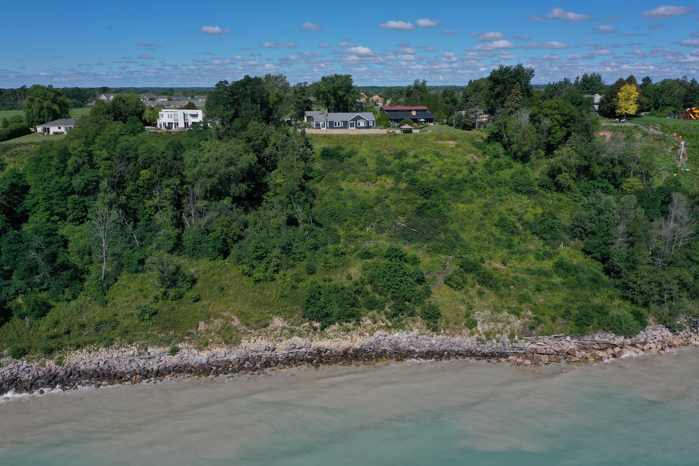 The house belonging to David Spector (blue house, center) is seen on a 120-foot bluff in Mequon, Wis.