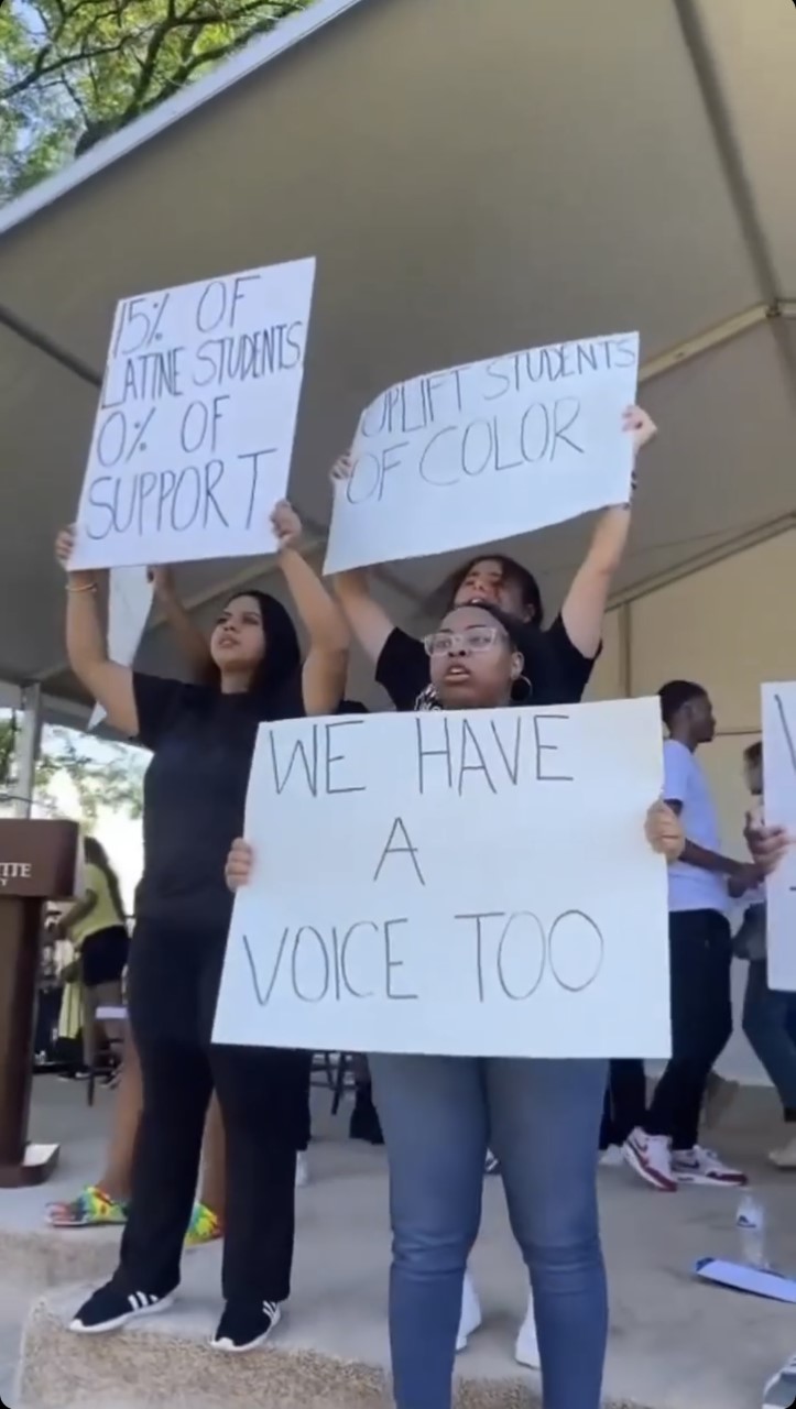 Students with the Black Student Council of Marquette hold signs during a protest