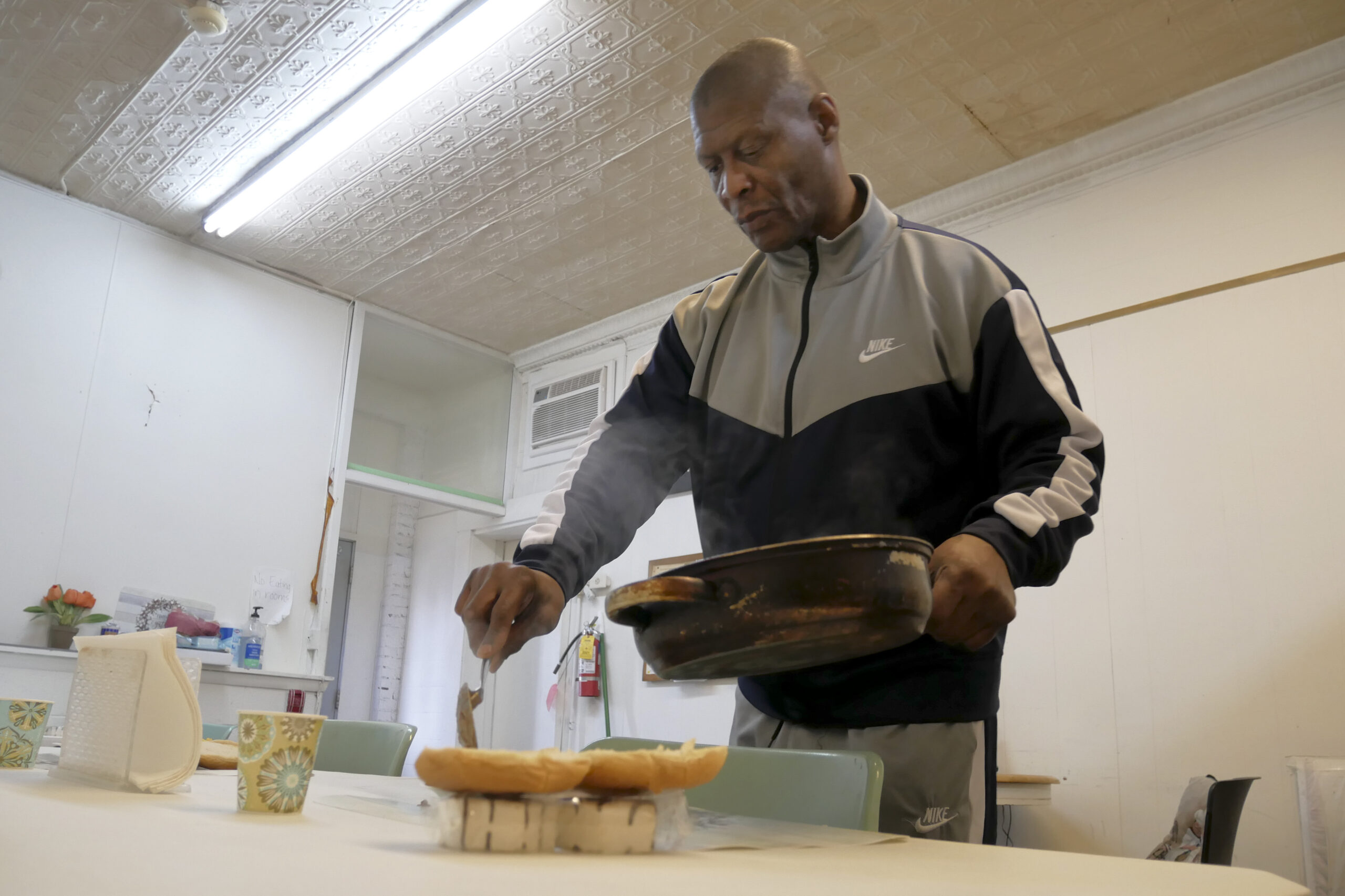 Tony Moore talks while preparing lunch for residents at his group home in Kenosha, Wis.