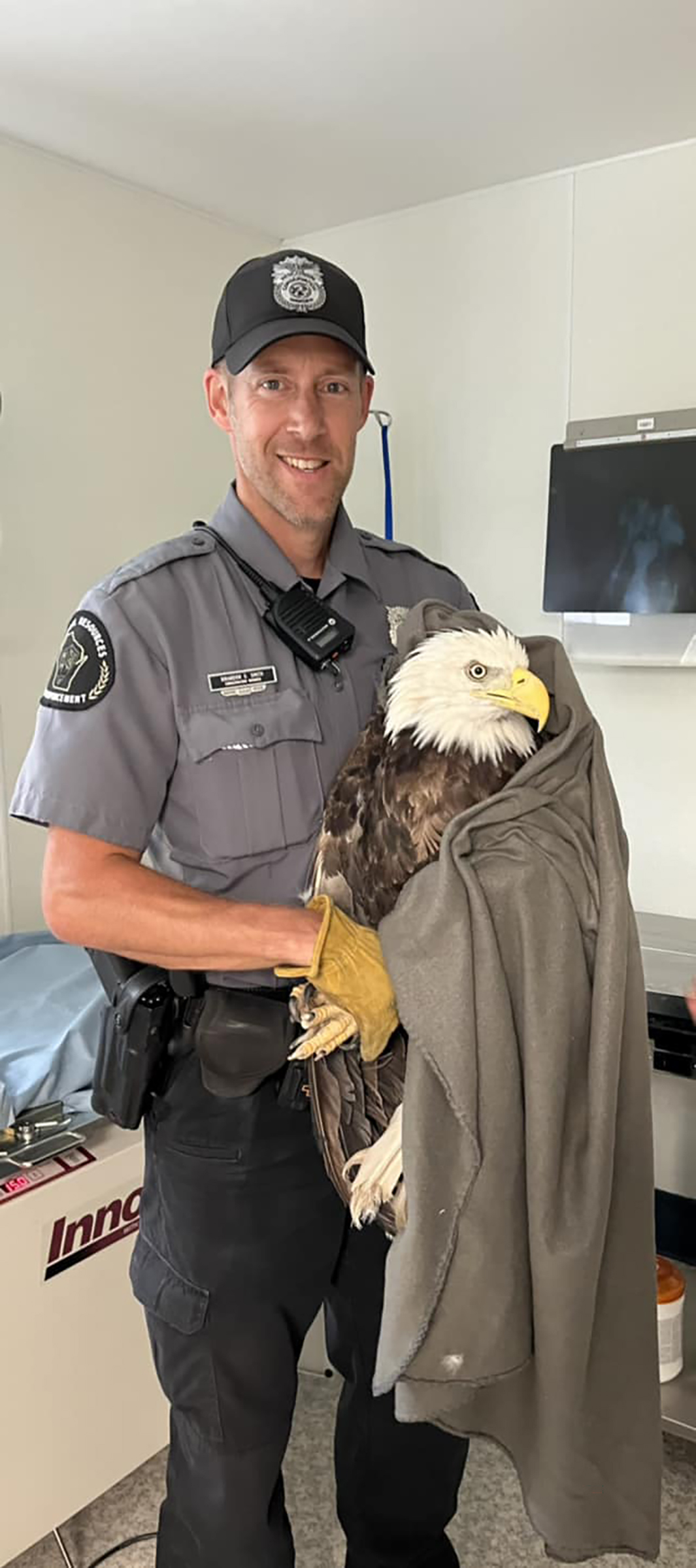 Warden Brandon Smith holds bald eagle that was shot in Racine County
