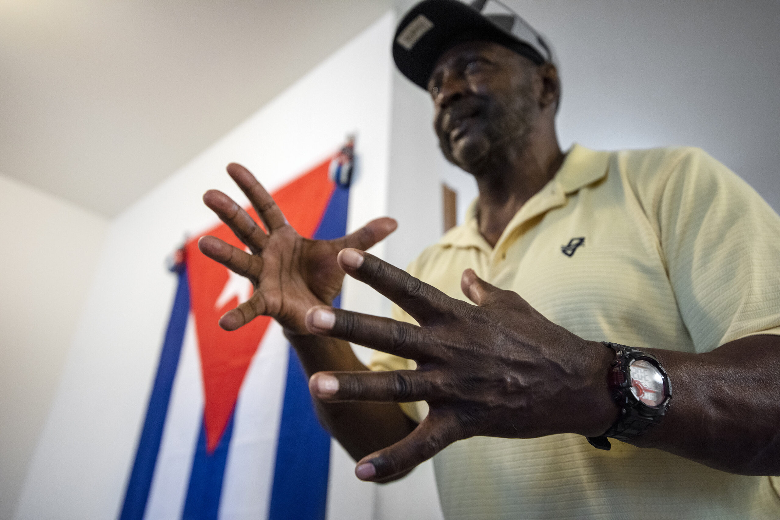 Osvaldo Durruthy stands in front of a Cuban flag