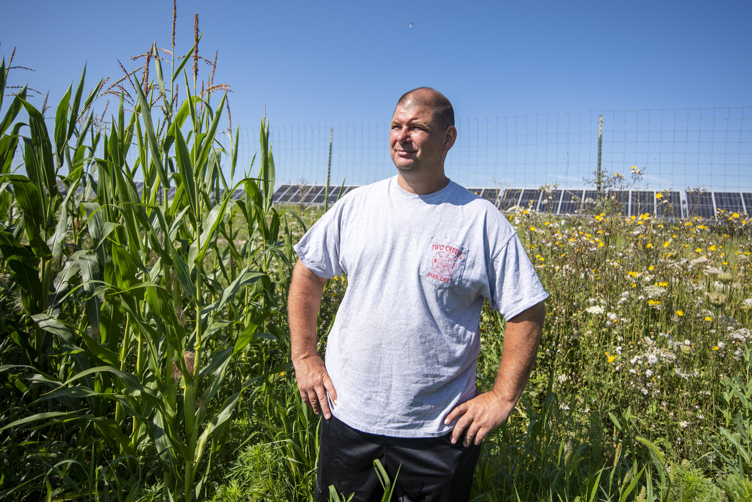 Brent Sinkula stands near the solar panels on his farm.
