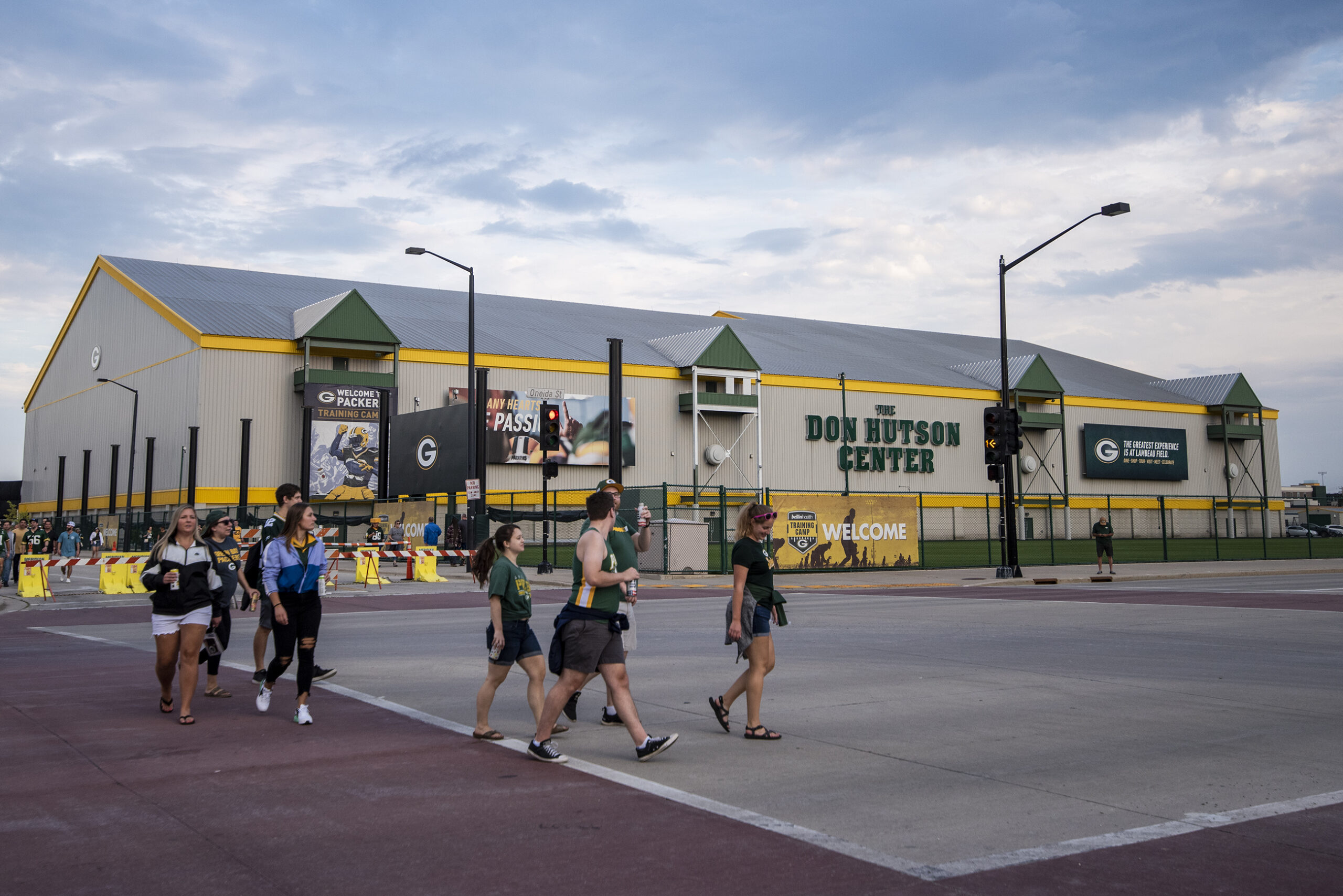 A gray and white building is seen in the background as fans cross a street.