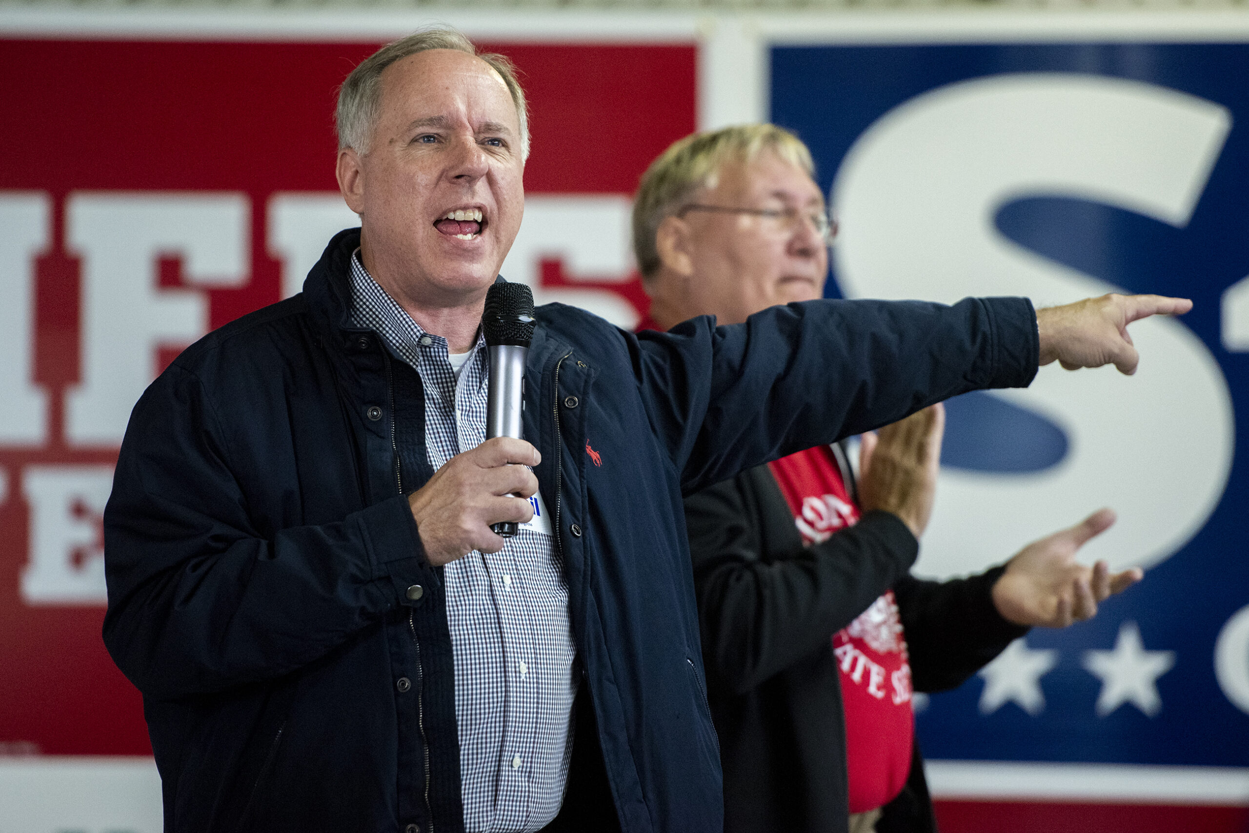 Assembly Speaker Robin Vos uses his hand to point to the side while speaking into a microphone.