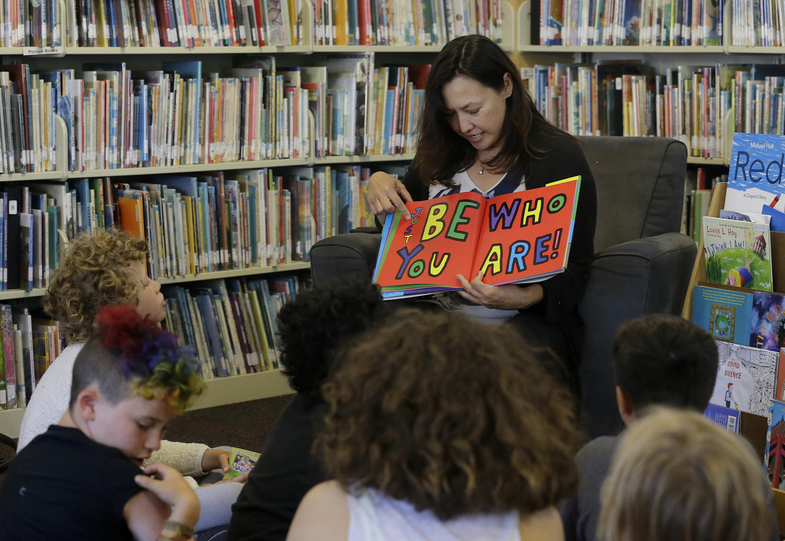 Sandra Collins reads a book to campers at the Bay Area Rainbow Day Camp