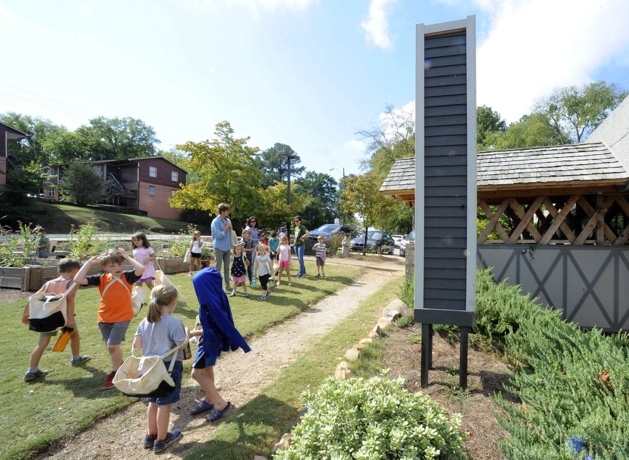 children play near a fake chimney used as housing for the migratory birds