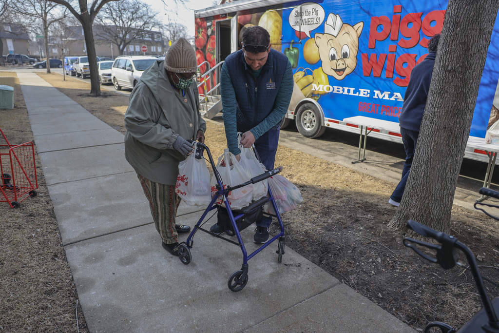 Lois Brown is helped with her groceries by Rick Lewandowski, director of senior services at the Hunger Task Force