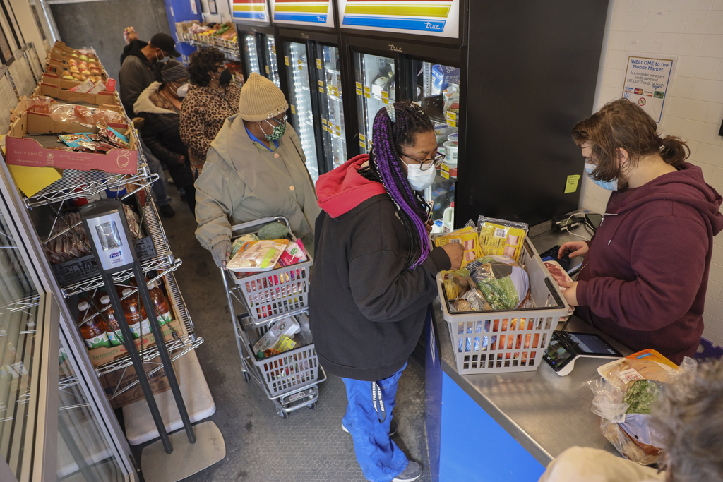 Shoppers wait in line to check out at the Hunger Task Force Mobile Market