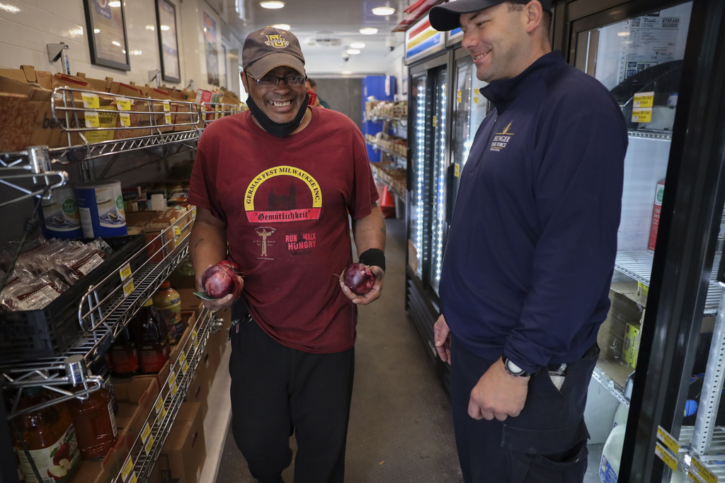 Richard Coleman checks out after buying red onions at the Hunger Task Force Mobile Market