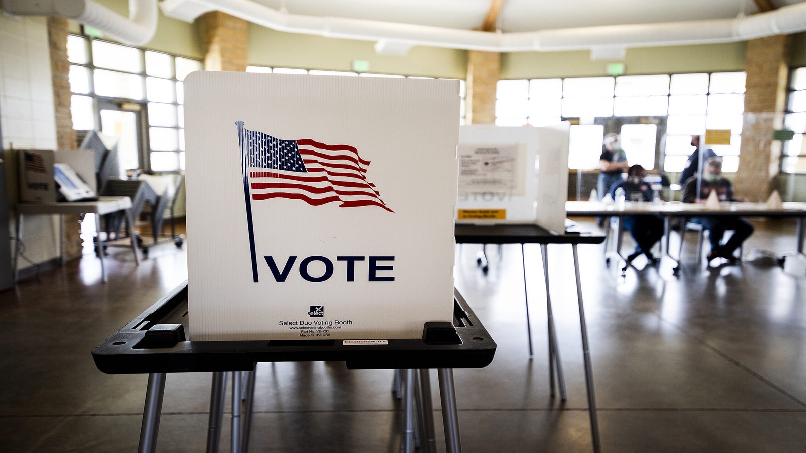 A voting booth says "VOTE" with a U.S. flag