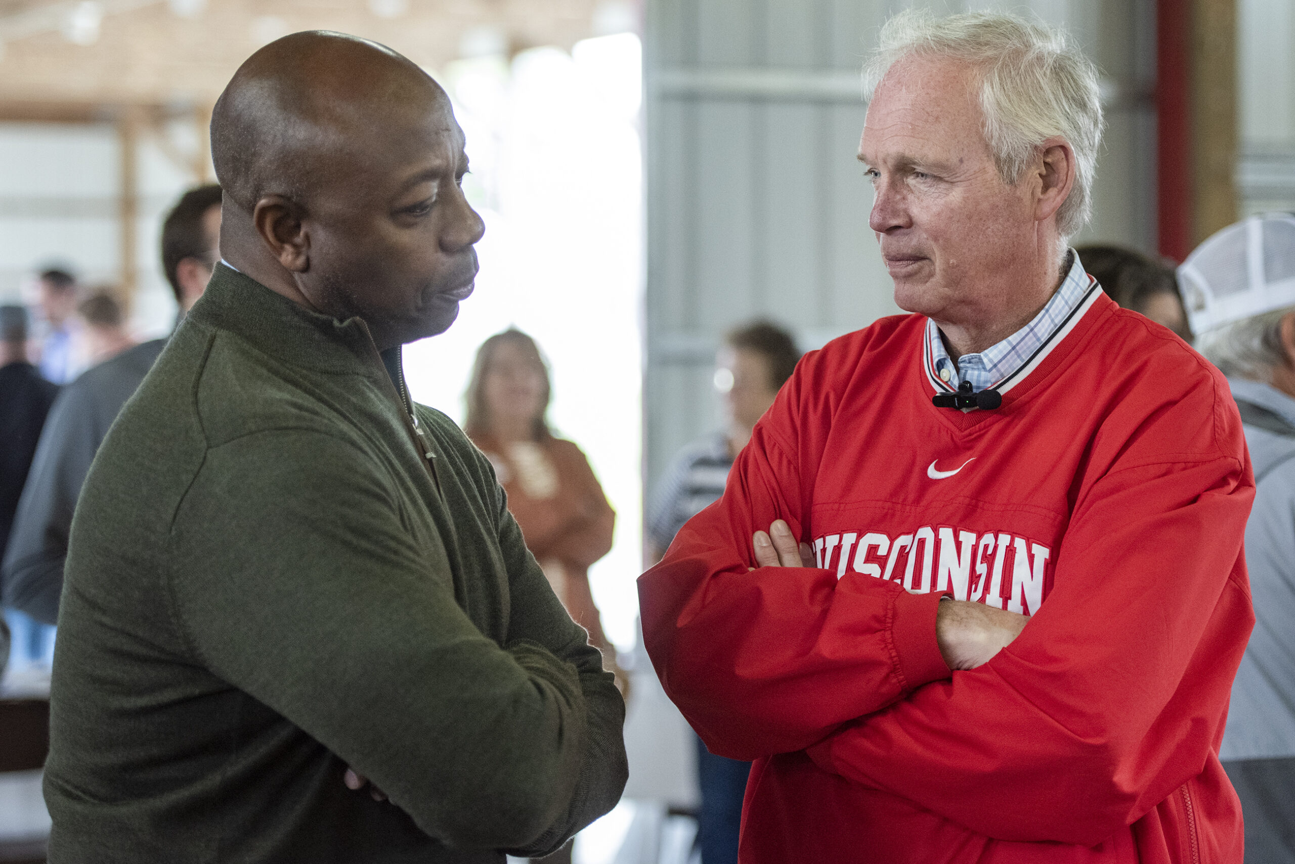 Sen. Ron Johnson stands next to Sen. Tim Scott as they speak to one another.