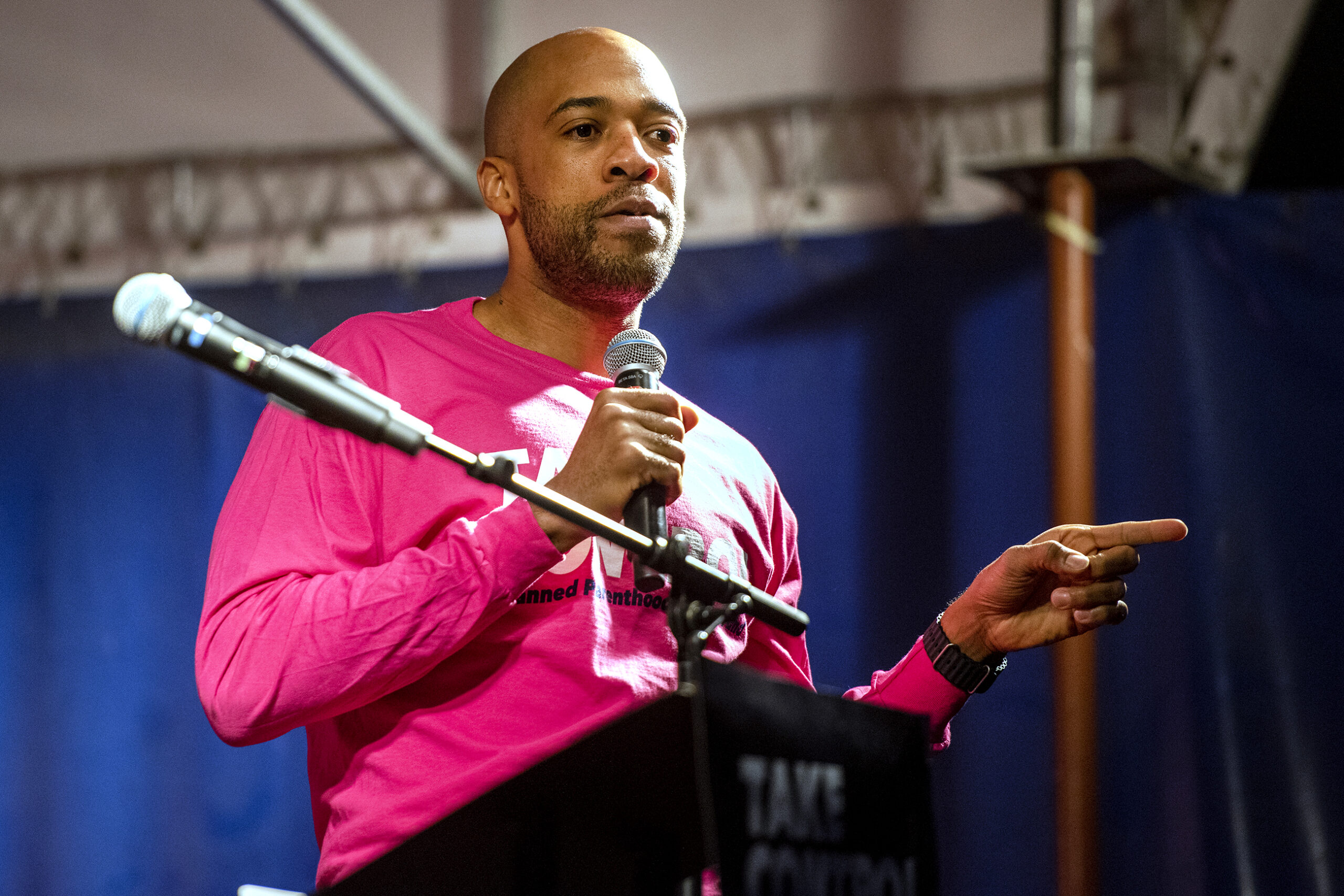 Lt. Gov. Mandela Barnes wears a pink Planned Parenthood shirt while speaking on stage.