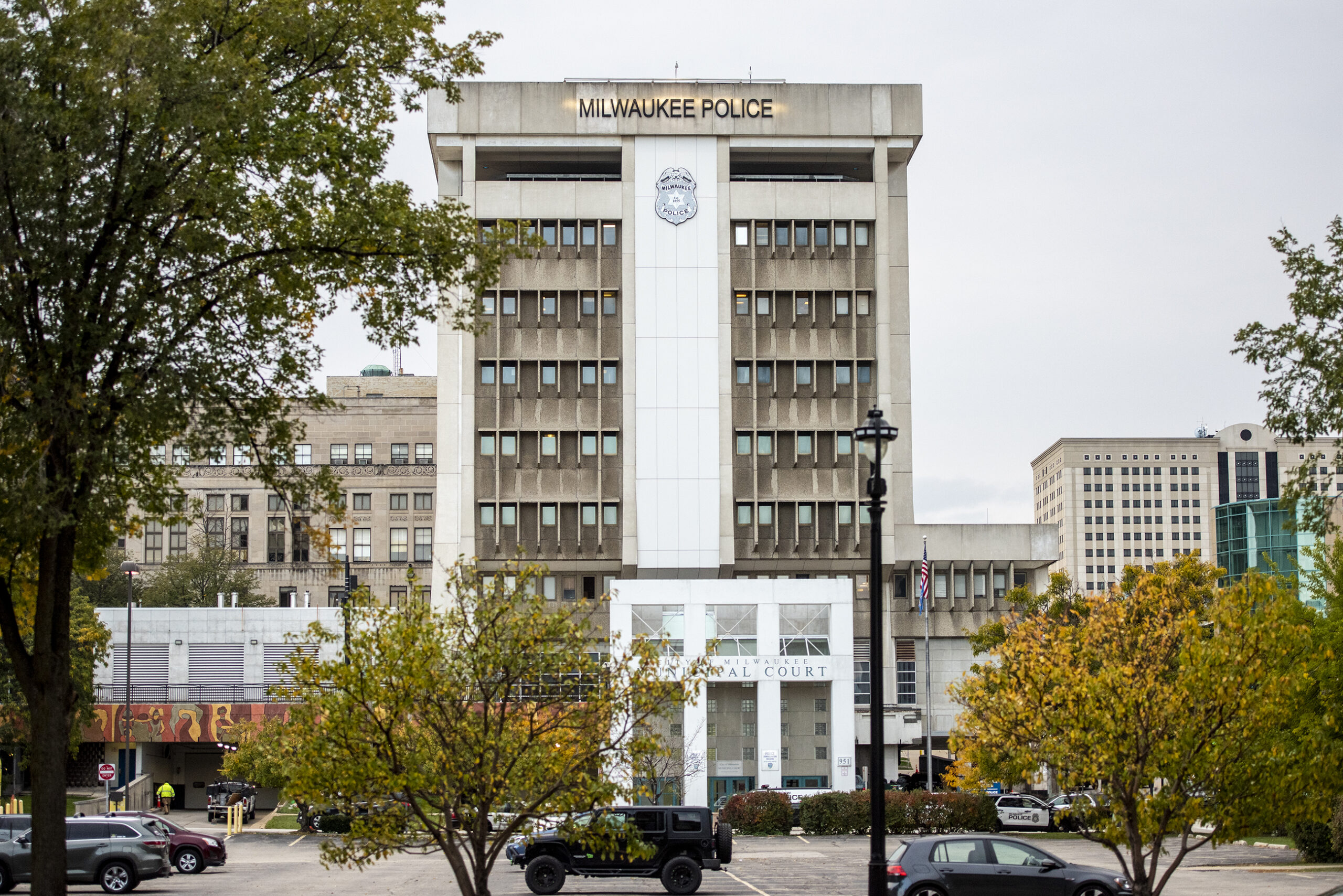 Trees surround a tall building that says "Milwaukee Police"