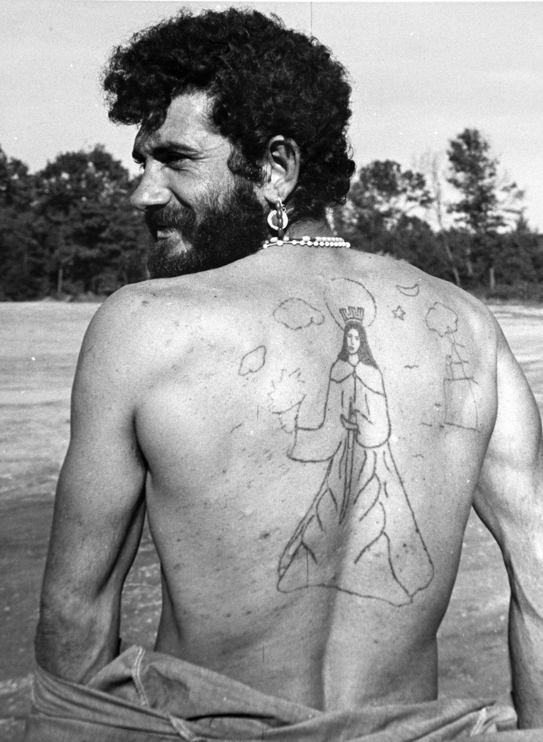 A Cuban refugees shows his back with a tattoo of Saint Barbara