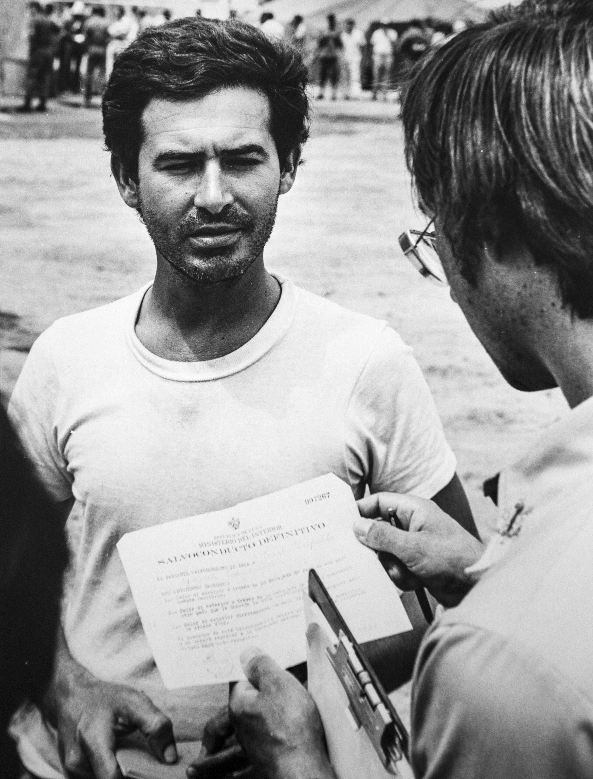 A Cuban refugee shows his visa to an interpreter