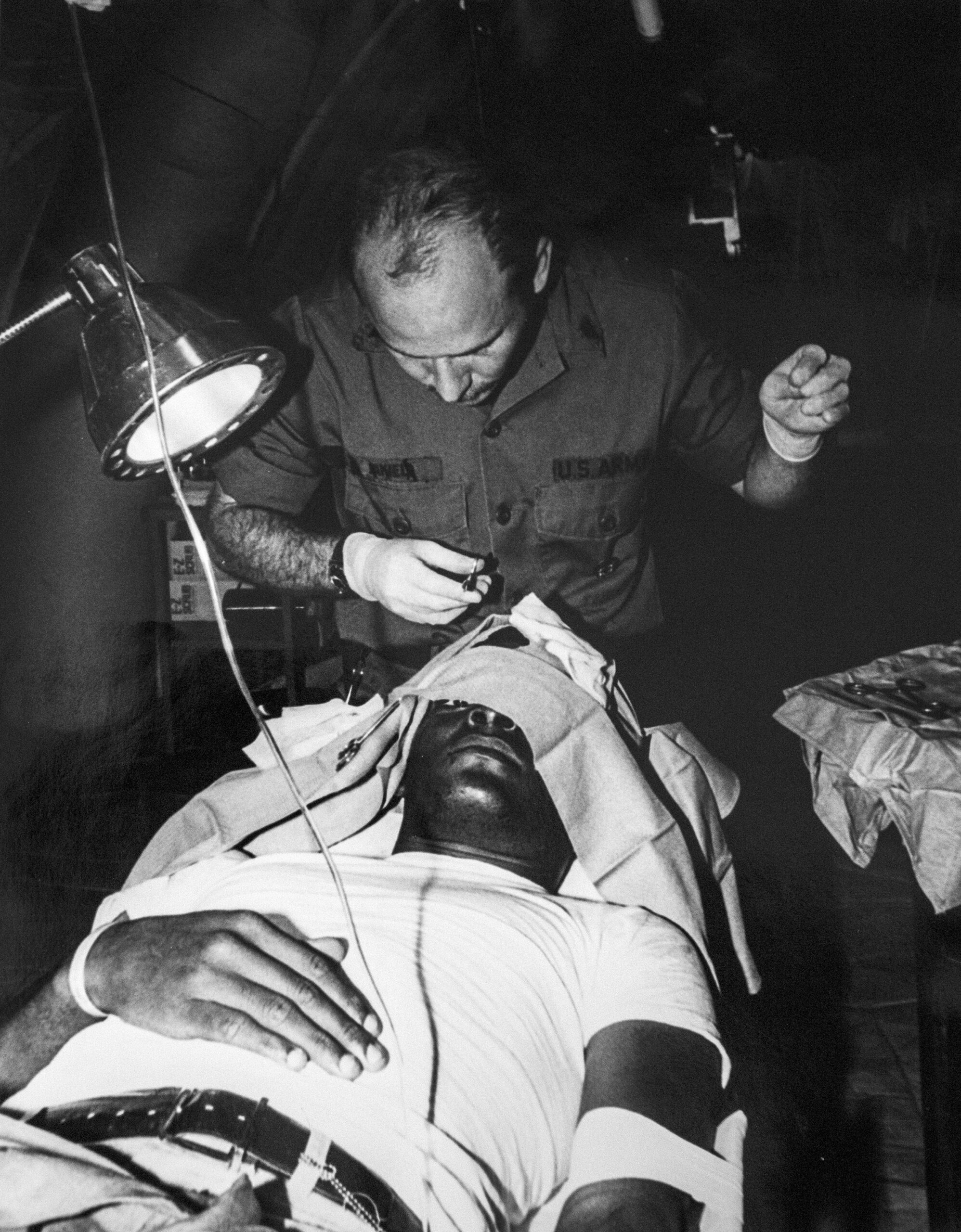 A Cuban refugee gets stitches in his head by a Fort McCoy medical professional
