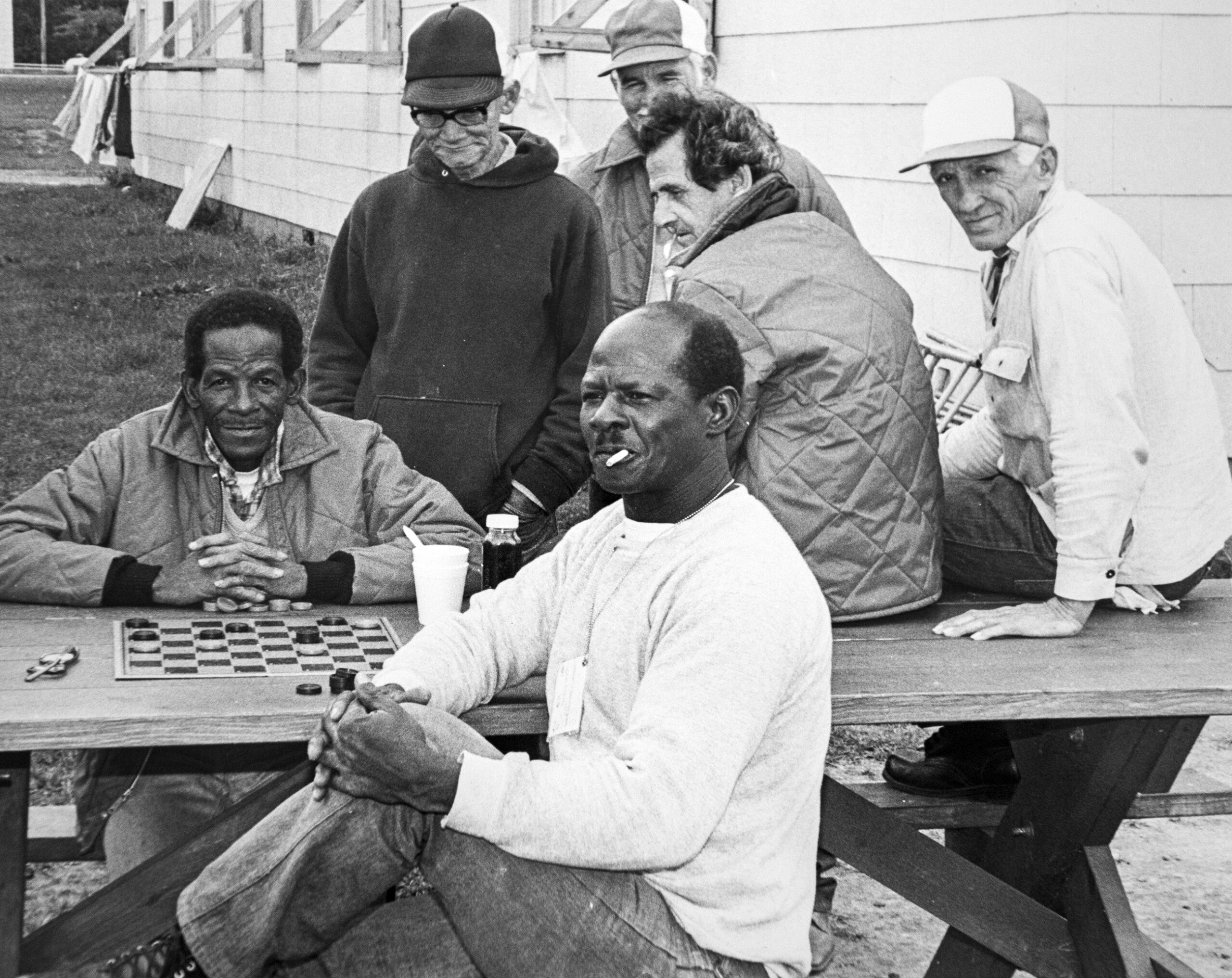 Cuban refugees play checkers at a picnic table