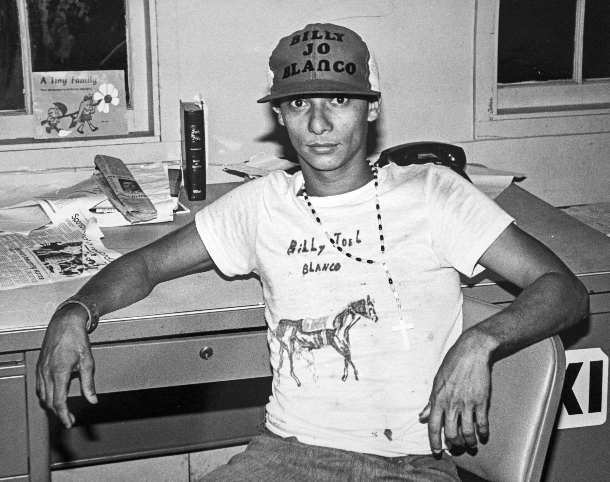 Luis Naranjo Soca, alias, Billy Joel Blaco, poses in a hand-painted shirt and a hat