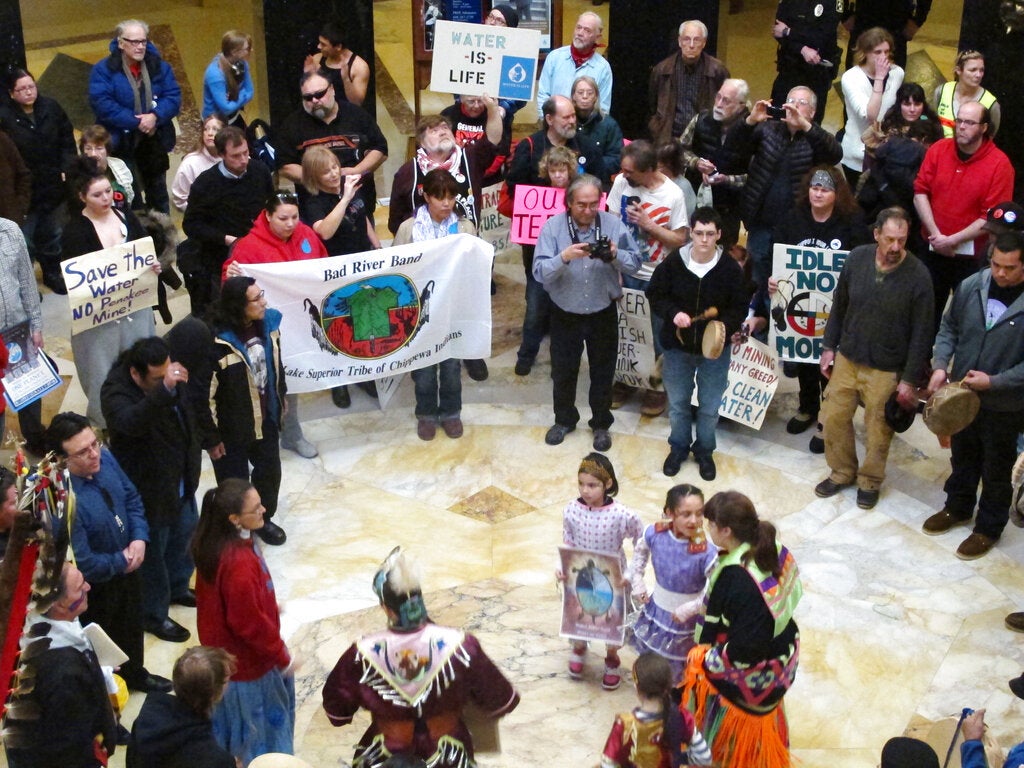 Protesters gather in the Wisconsin Capitol to speak out against a bill that would to ease the opening of a new iron ore mine.