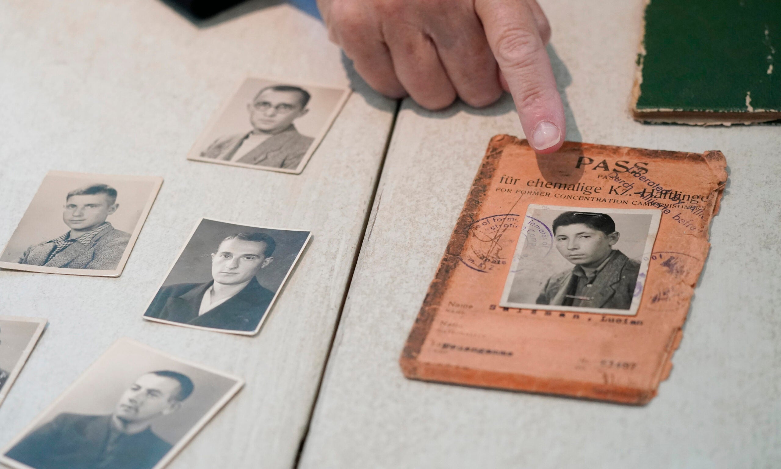 A woman points to a photo of her father, a Holocaust survivor