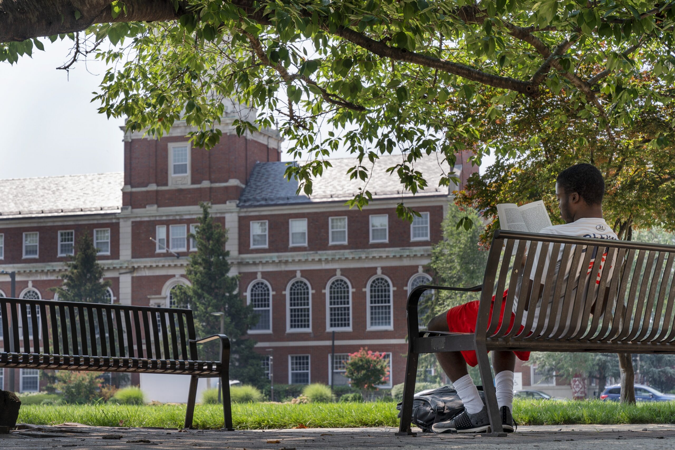 A young man reads on the Howard University campus.