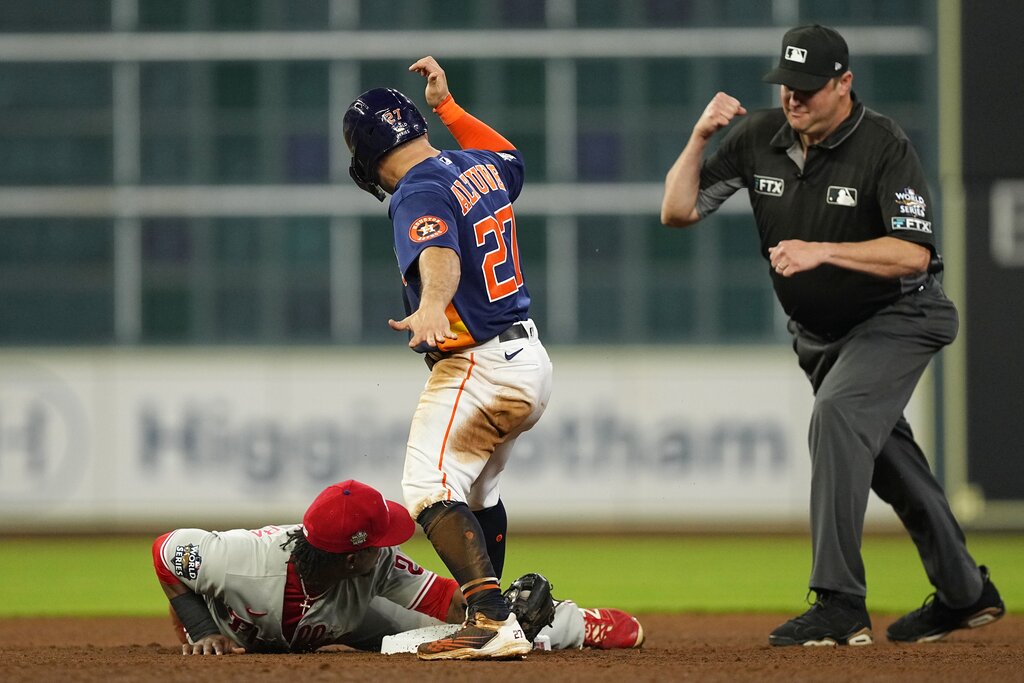 A baseball player tags another out at a base.
