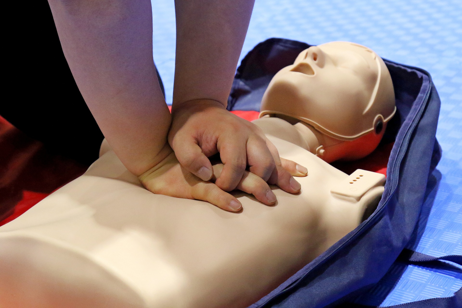 A person practices chest compressions on a CPR dummy