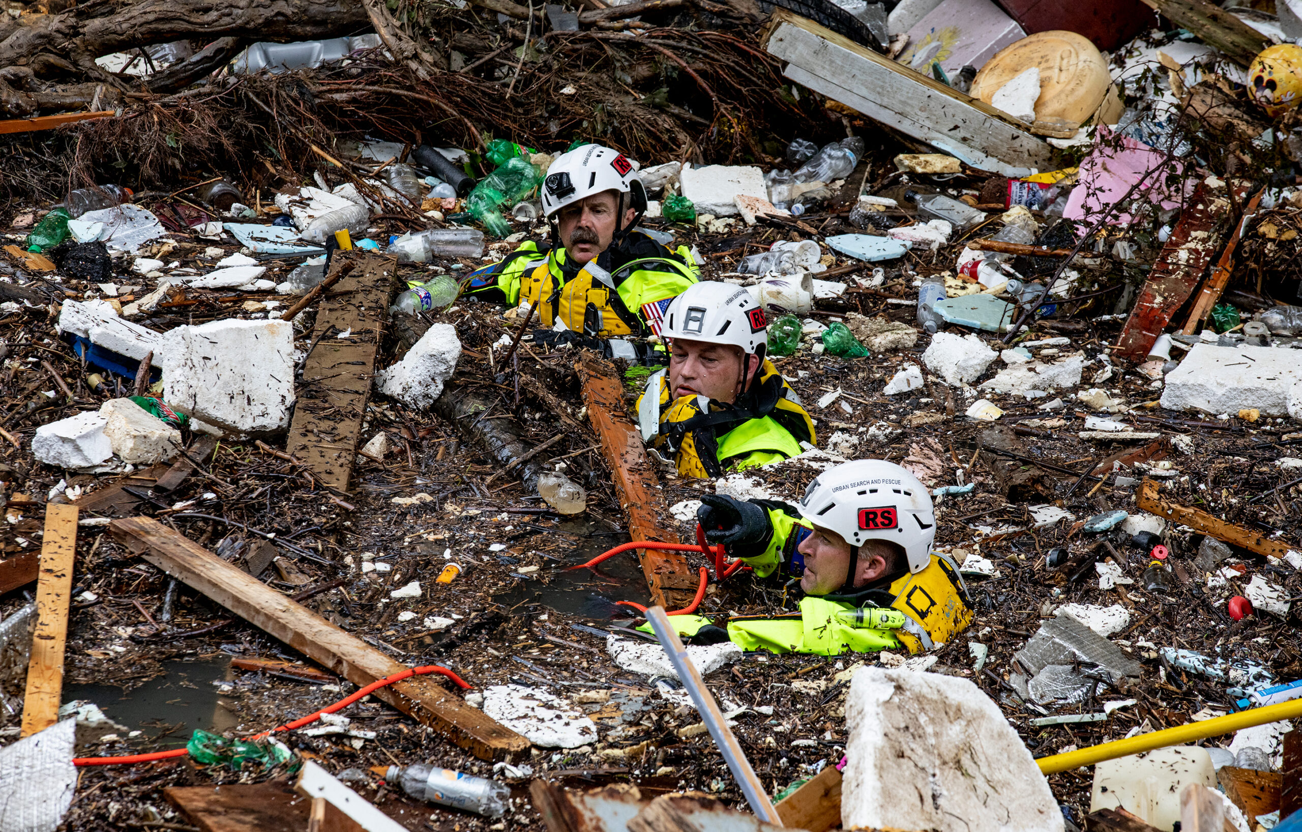 A search and rescue team wades through Troublesome Creek in Eastern Kentucky