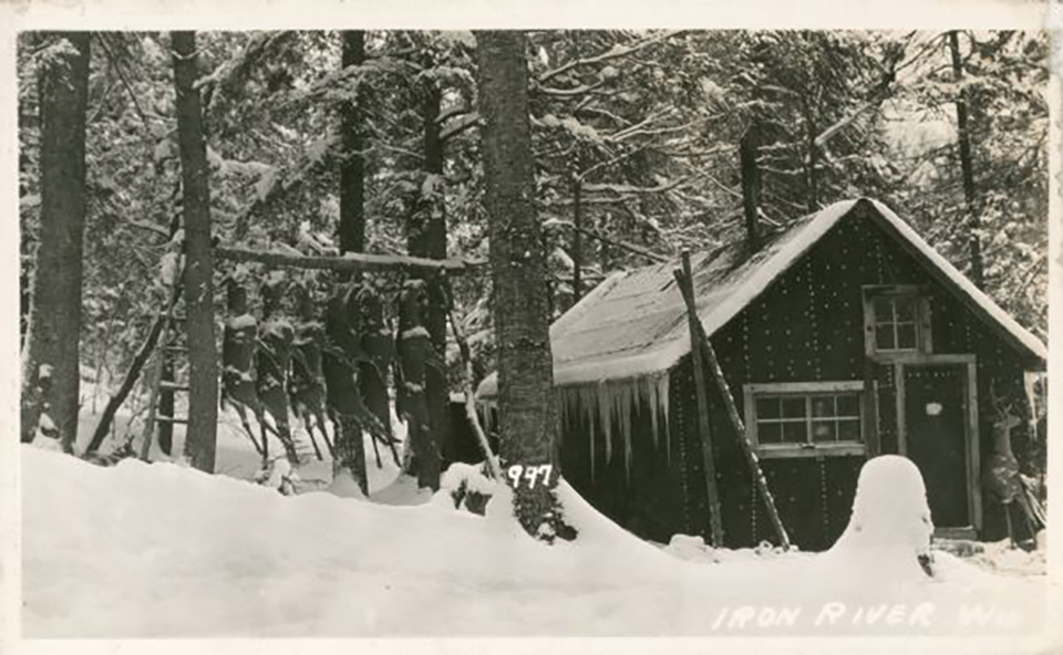 A photo titled "Iron River deer camp" shows the exterior view of a hunting camp in the snow around 1933 in Iron River