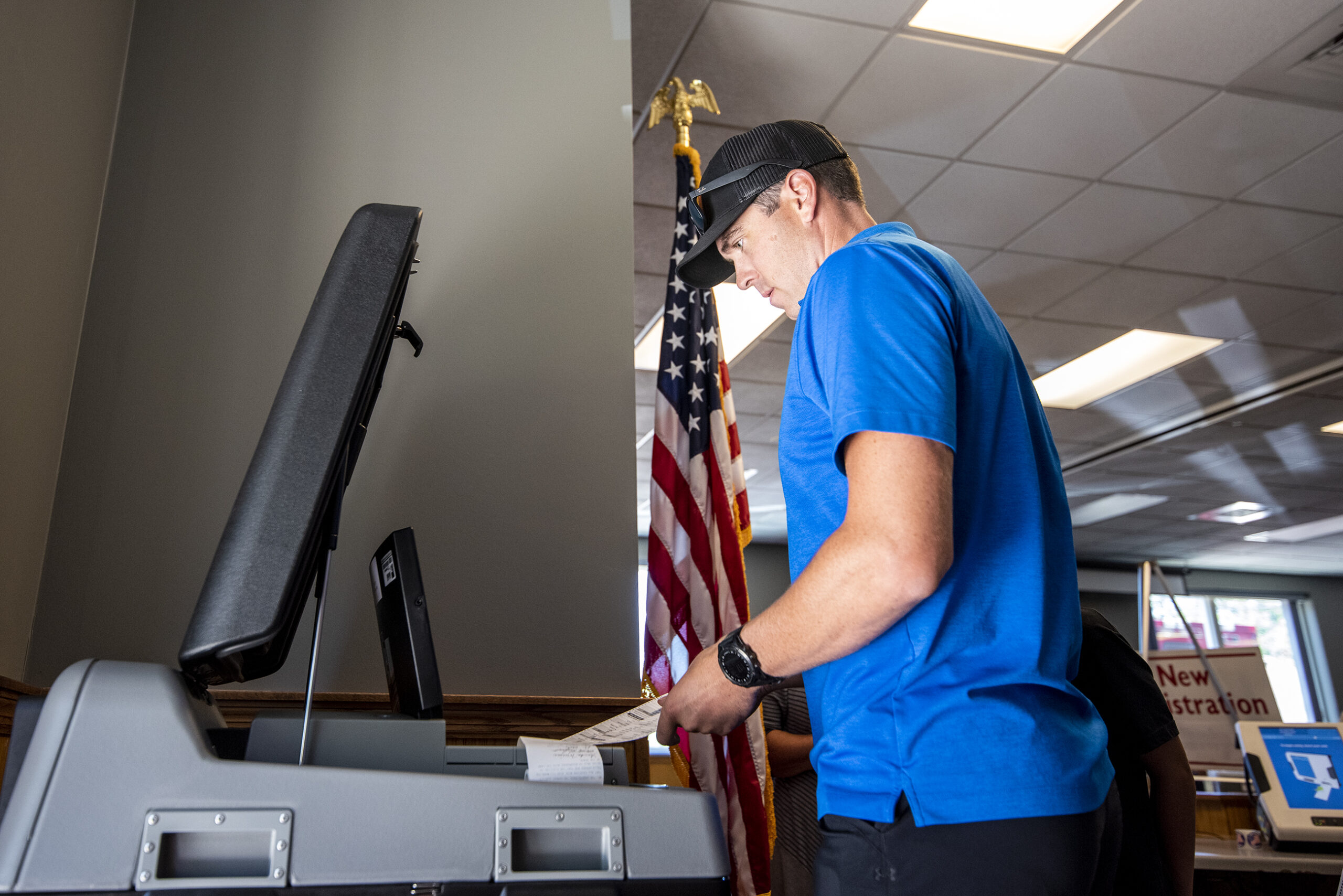 A man places his ballot into the counting machine.