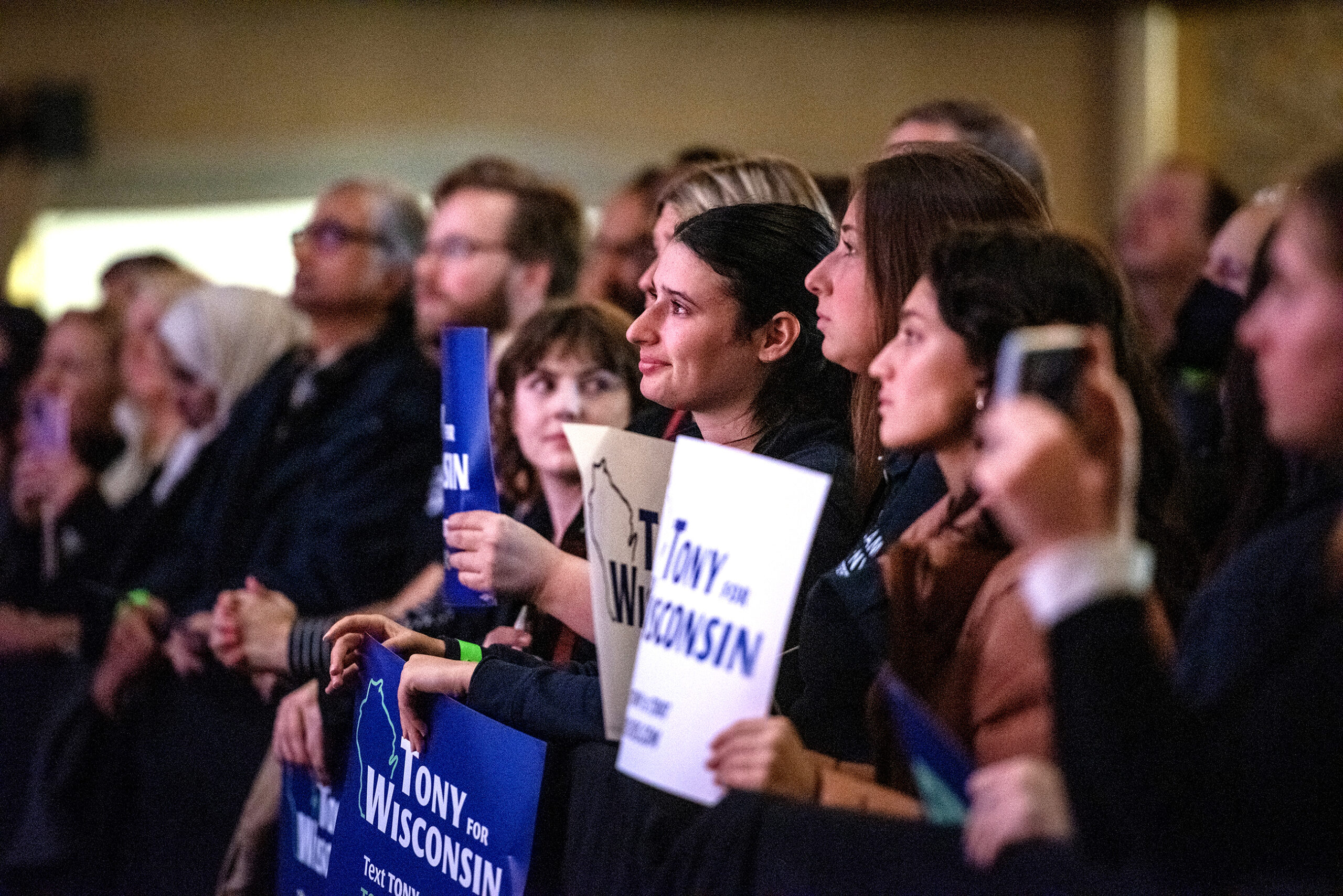 Women in the front row crowd around to listen to Gov. Evers' speech.