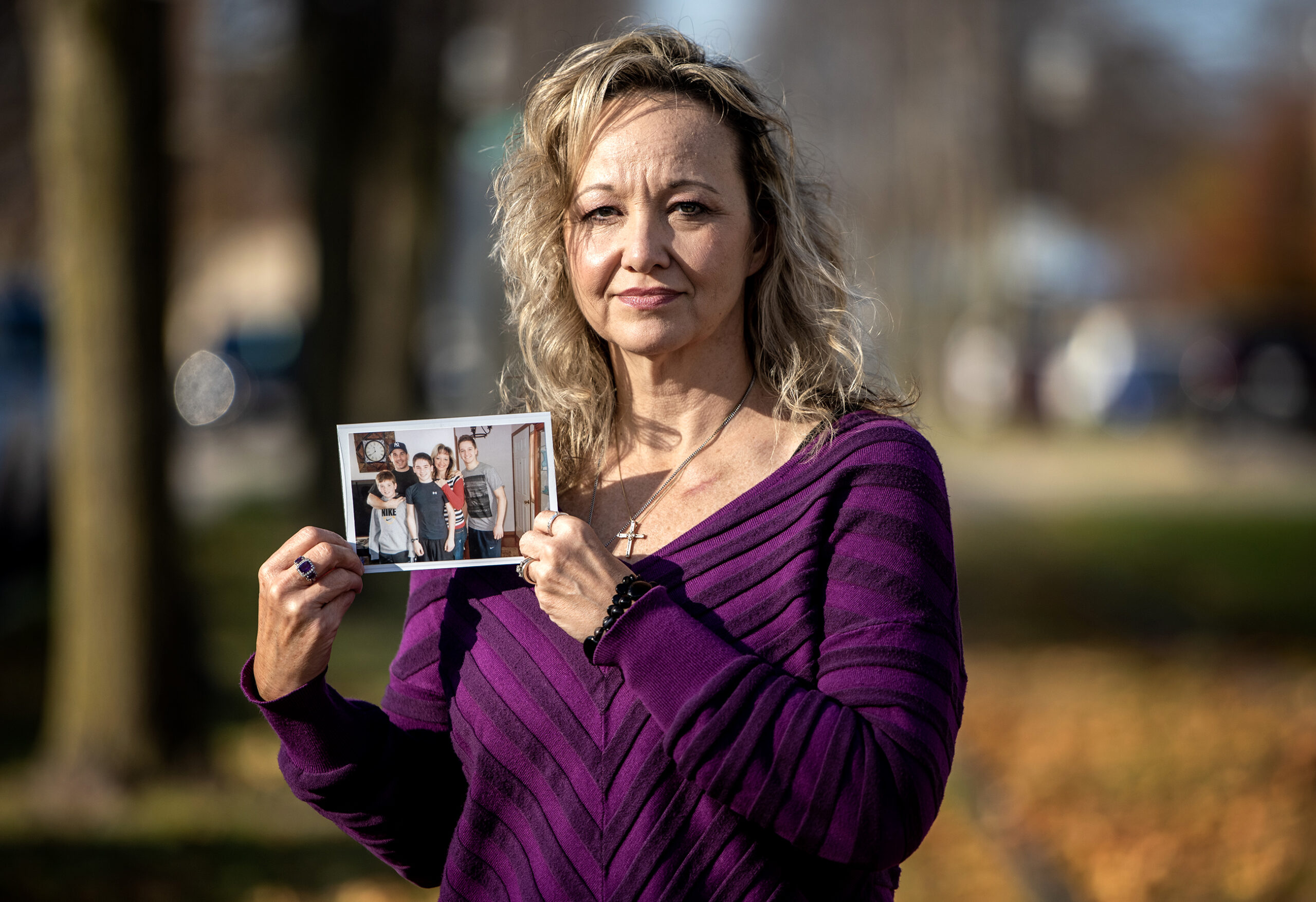 Felicia Labatore stands outside holding a printed photograph.