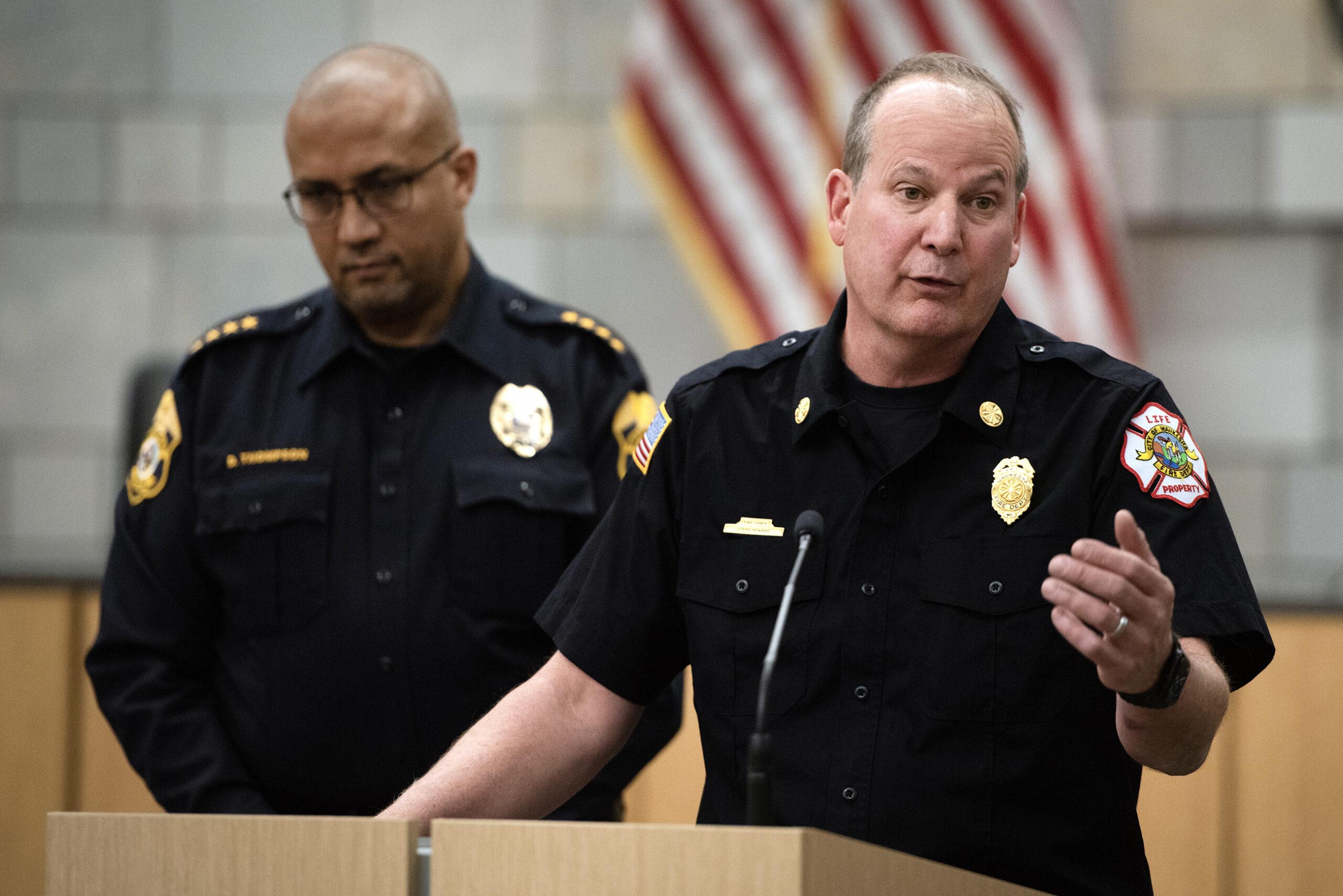 Two men stand together, one at a podium.