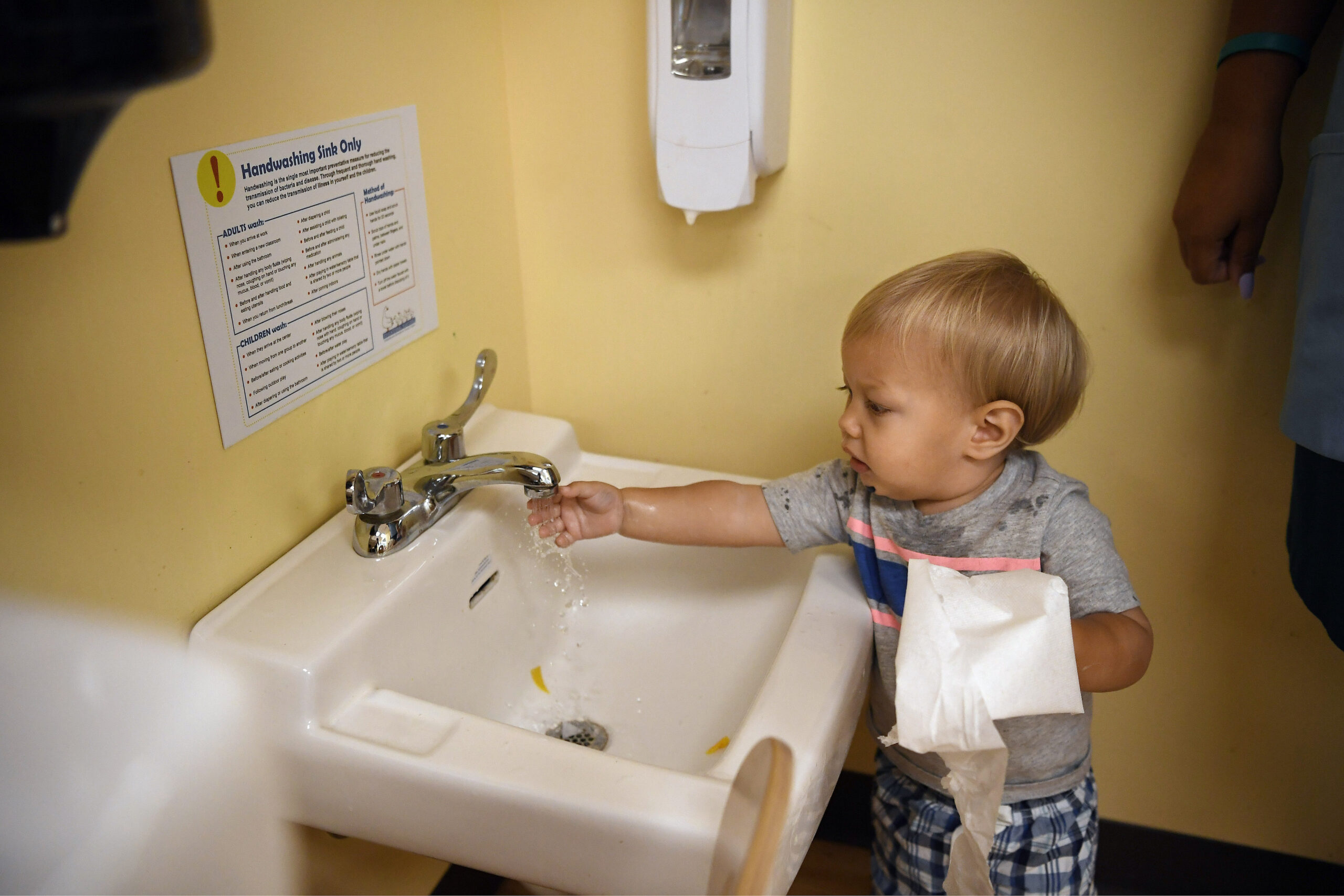 Toddler Owen Skelton washes his hands.