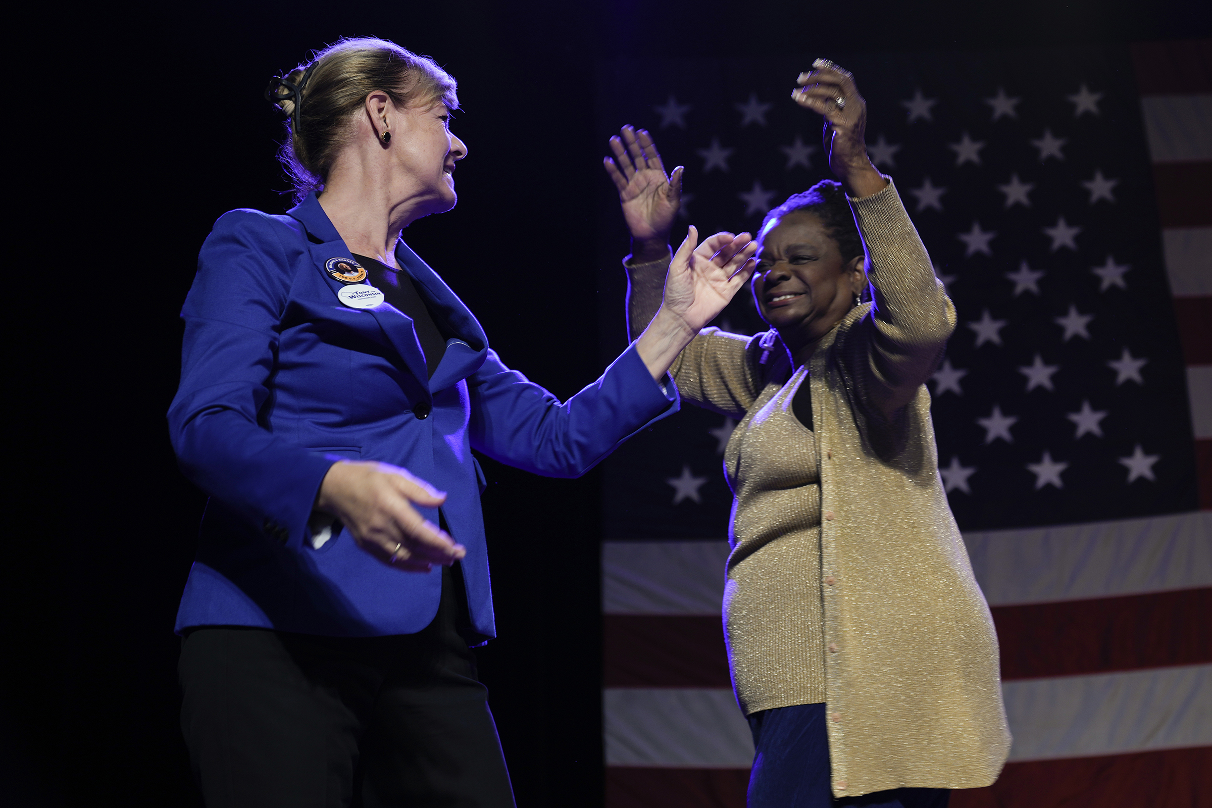 Tammy Baldwin and Gwen Moore smile on stage in support of Mandela Barnes
