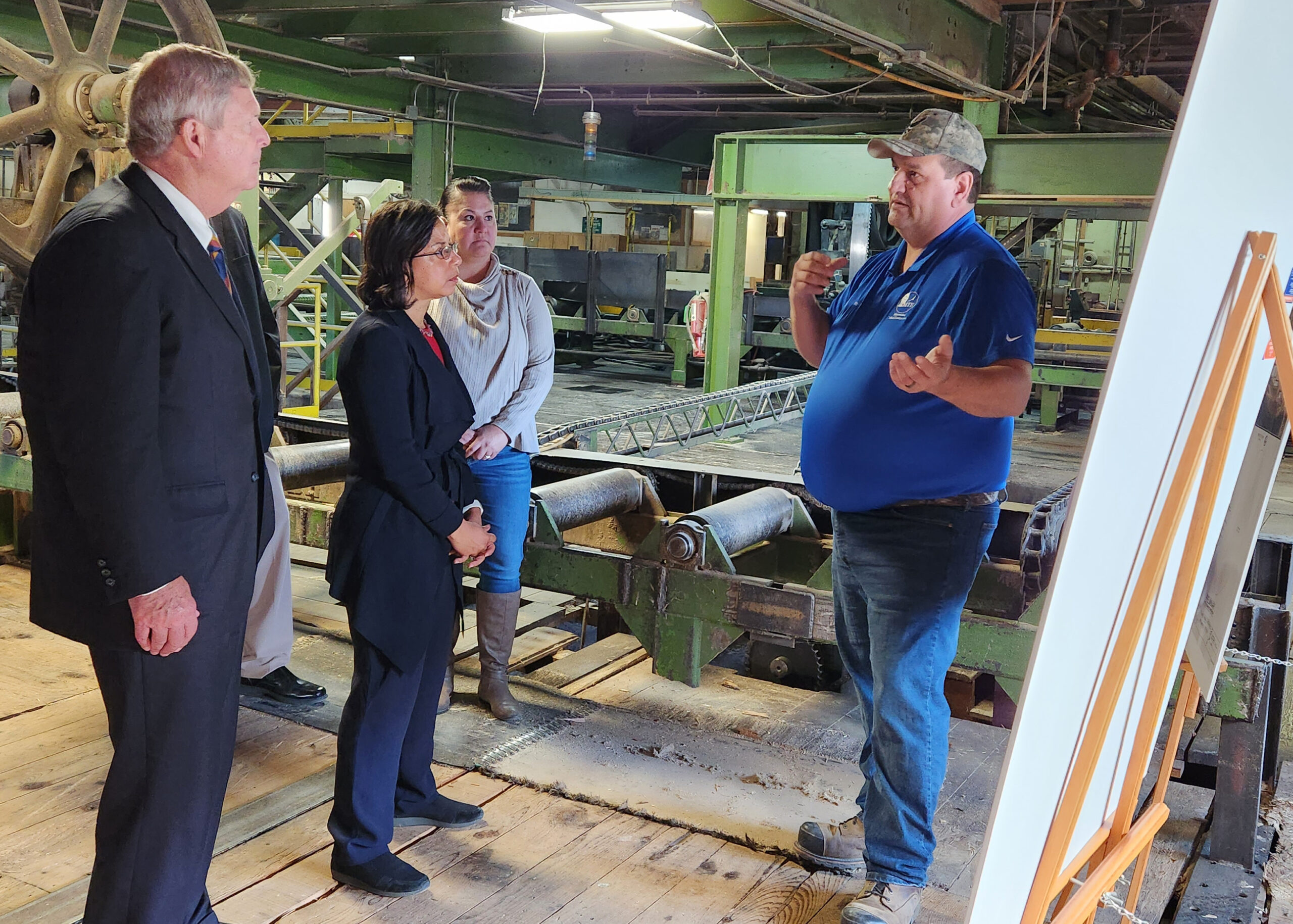 Menominee Tribal Enterprises Lumber Operations Manager John Awonohopay gives U.S. Department of Agriculture Secretary Tom Vilsack and White House Domestic Policy Advisor Susan Rice a tour of the sawmill.