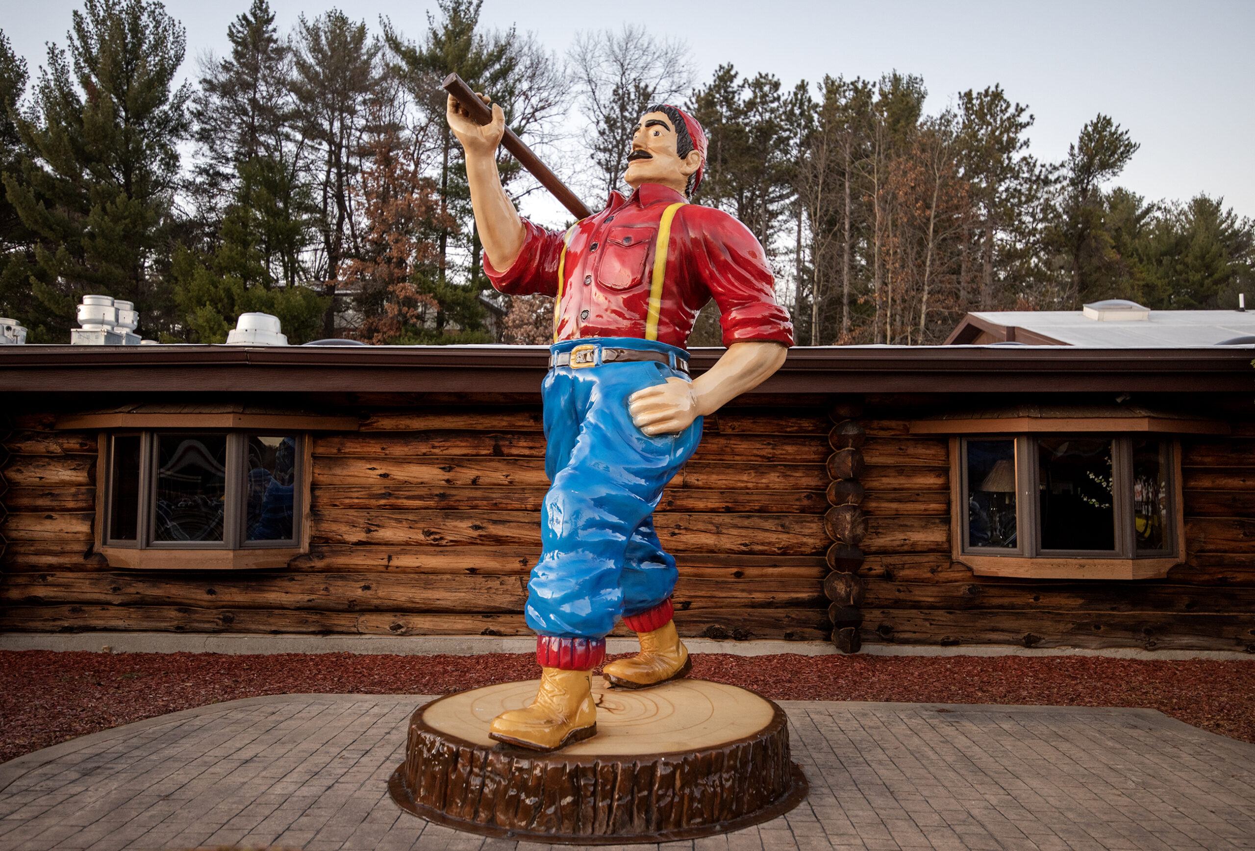 A statue of Paul Bunyan in a red shirt, suspenders, and boots.