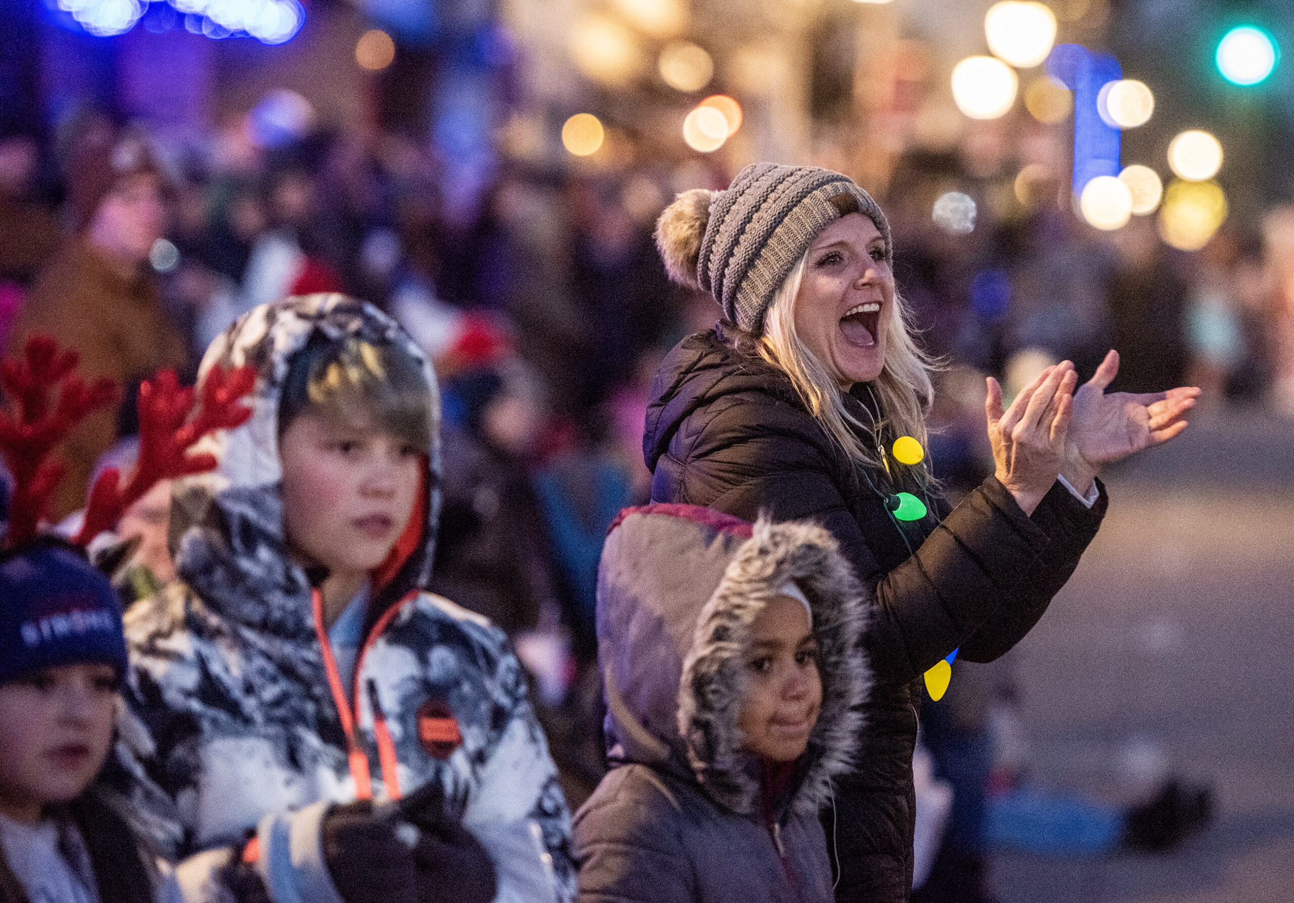 A parade attendee claps and cheers as the parade passes by.