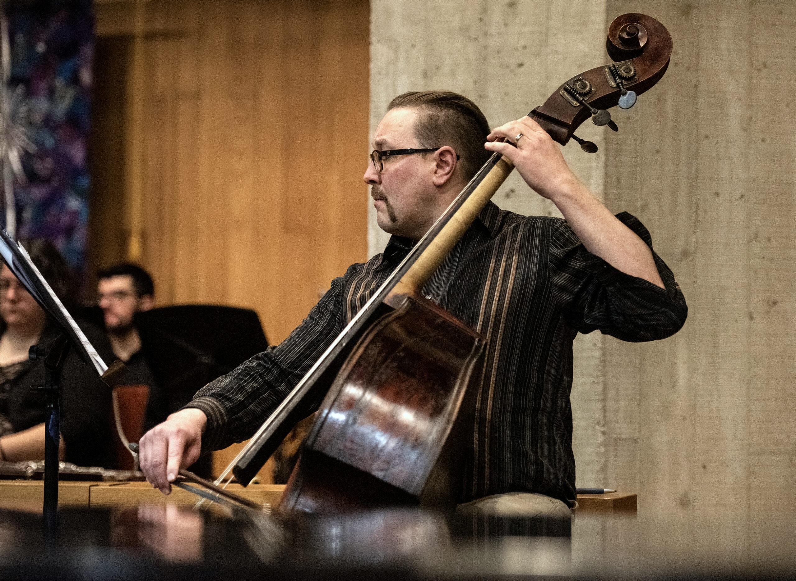 A musician plays a standing string instrument.