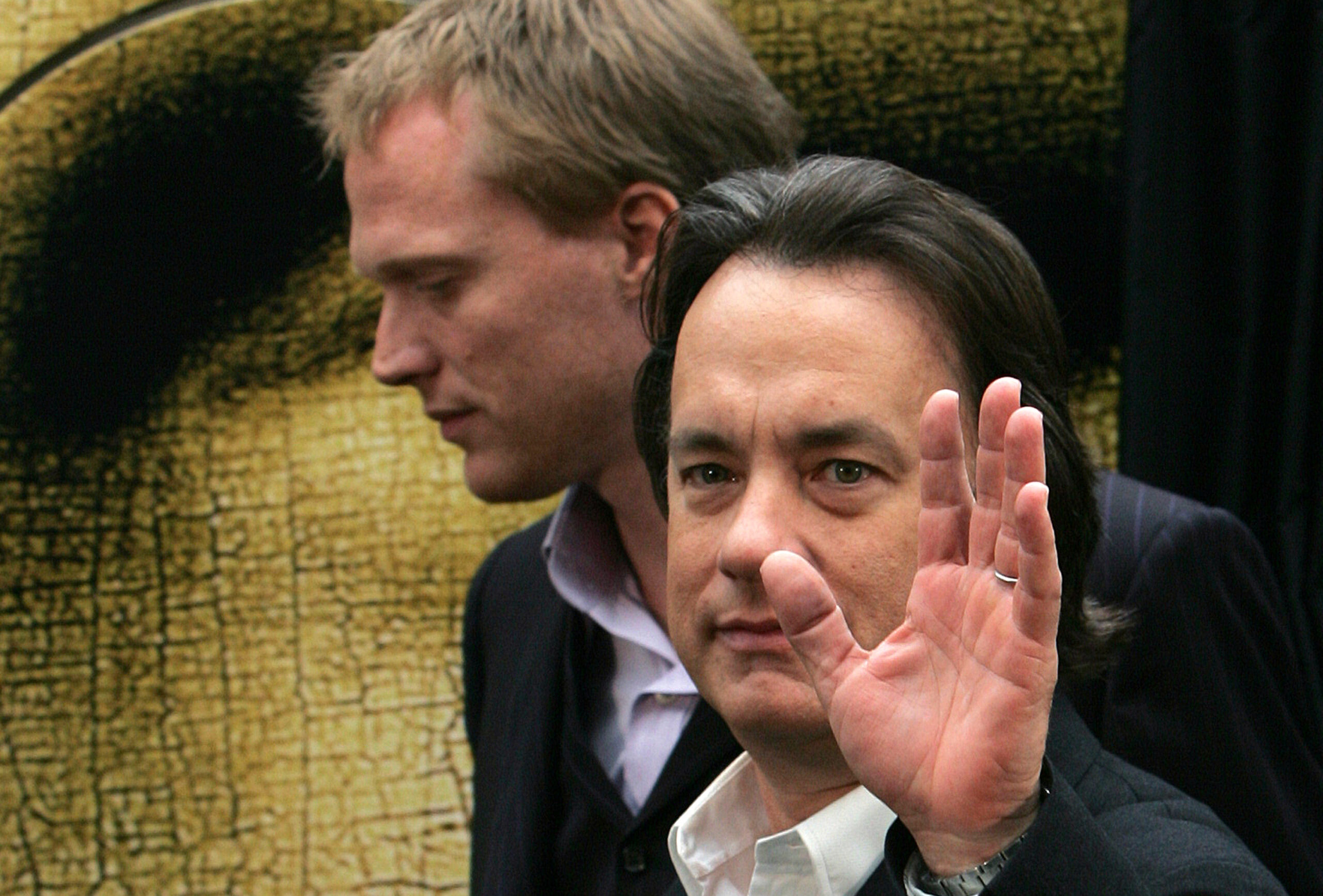 Actor Tom Hanks waves with actor Paul Betteny in the background