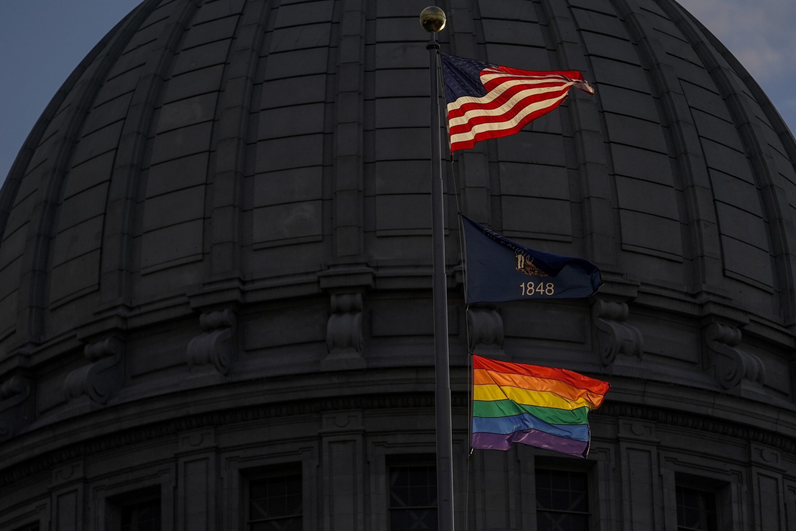 An LGBTQ flag flies over the Wisconsin State Capitol.