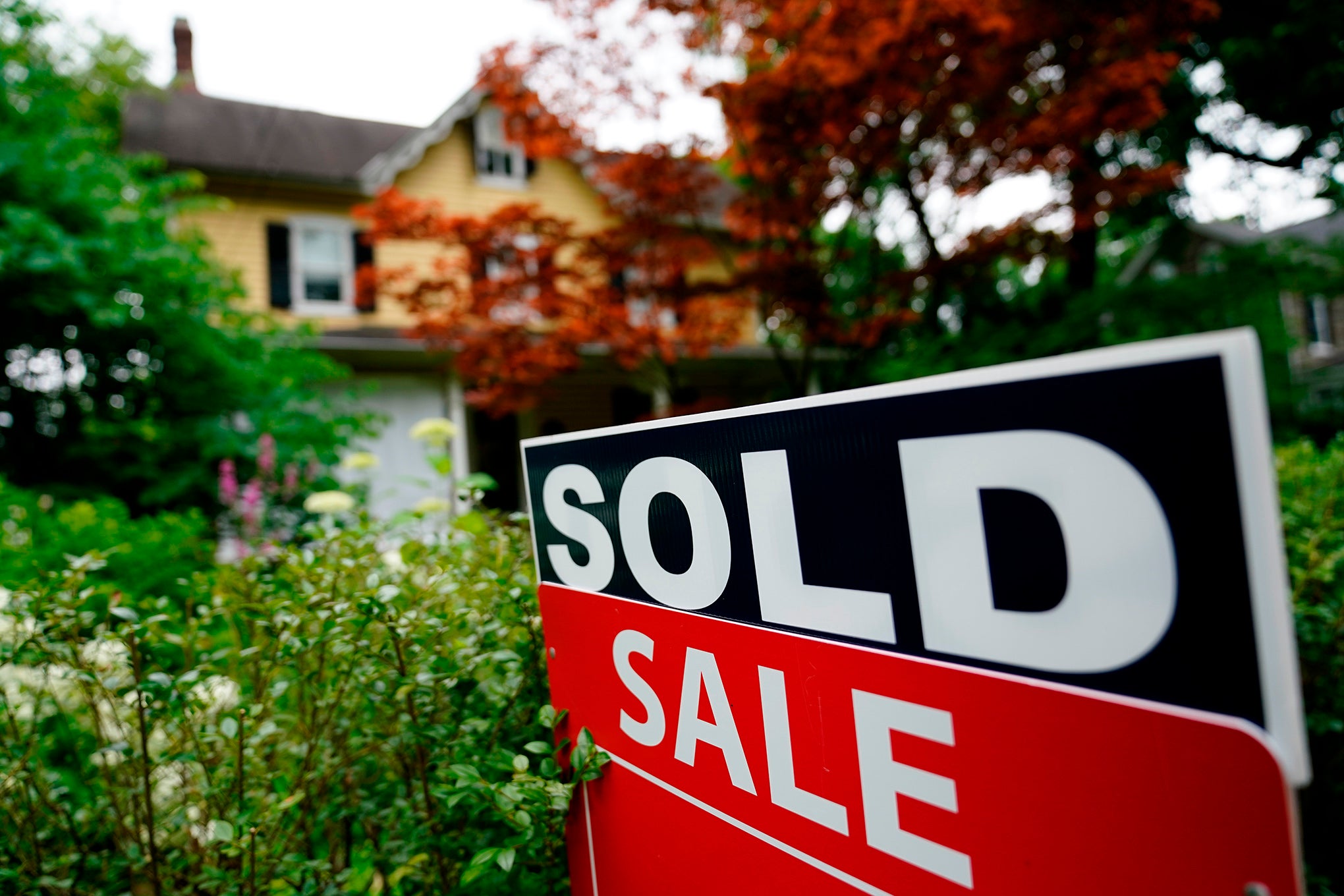 A sale sign stands outside a home.