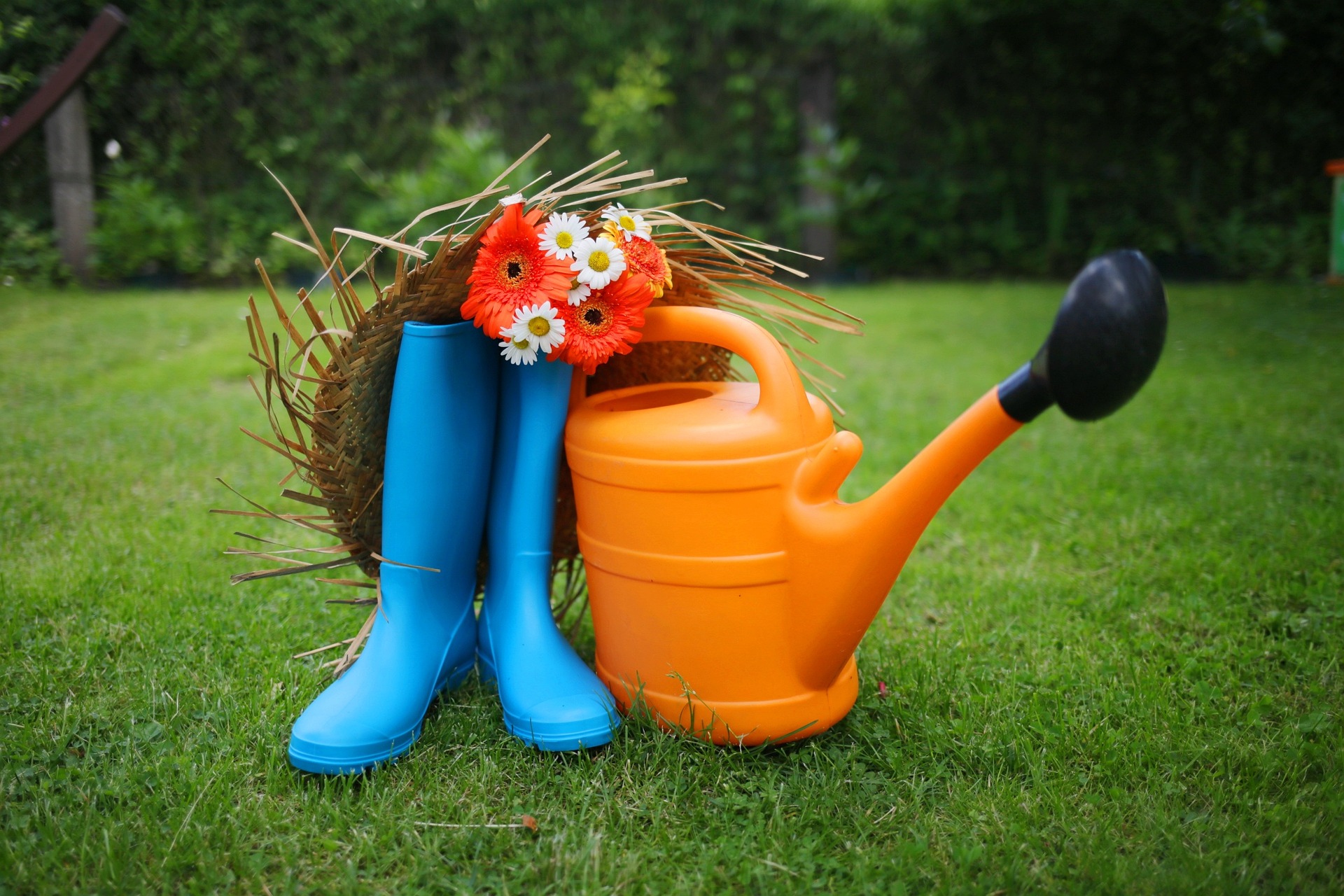 Blue gardening boots with orange watering can.