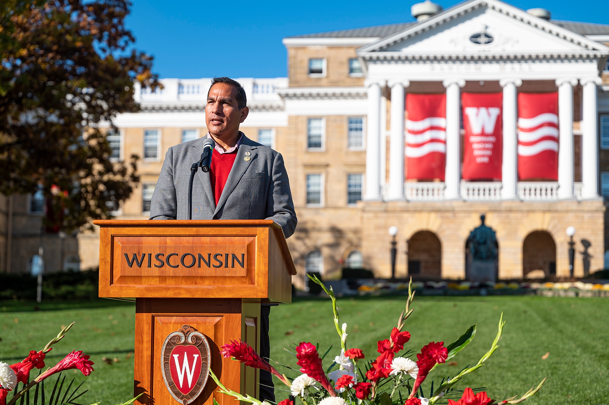 Aaron Bird Bear speaks at a podium in front of Bascom Hall