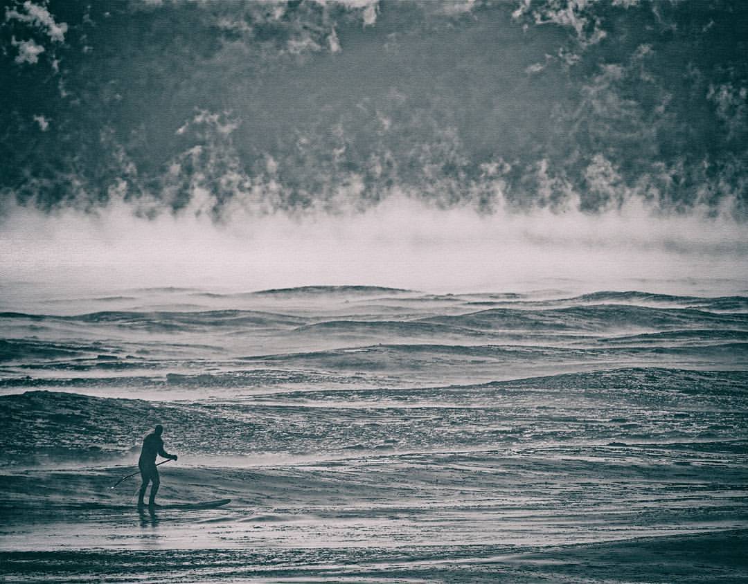 A man rides a stand-up paddleboard on Lake Michigan