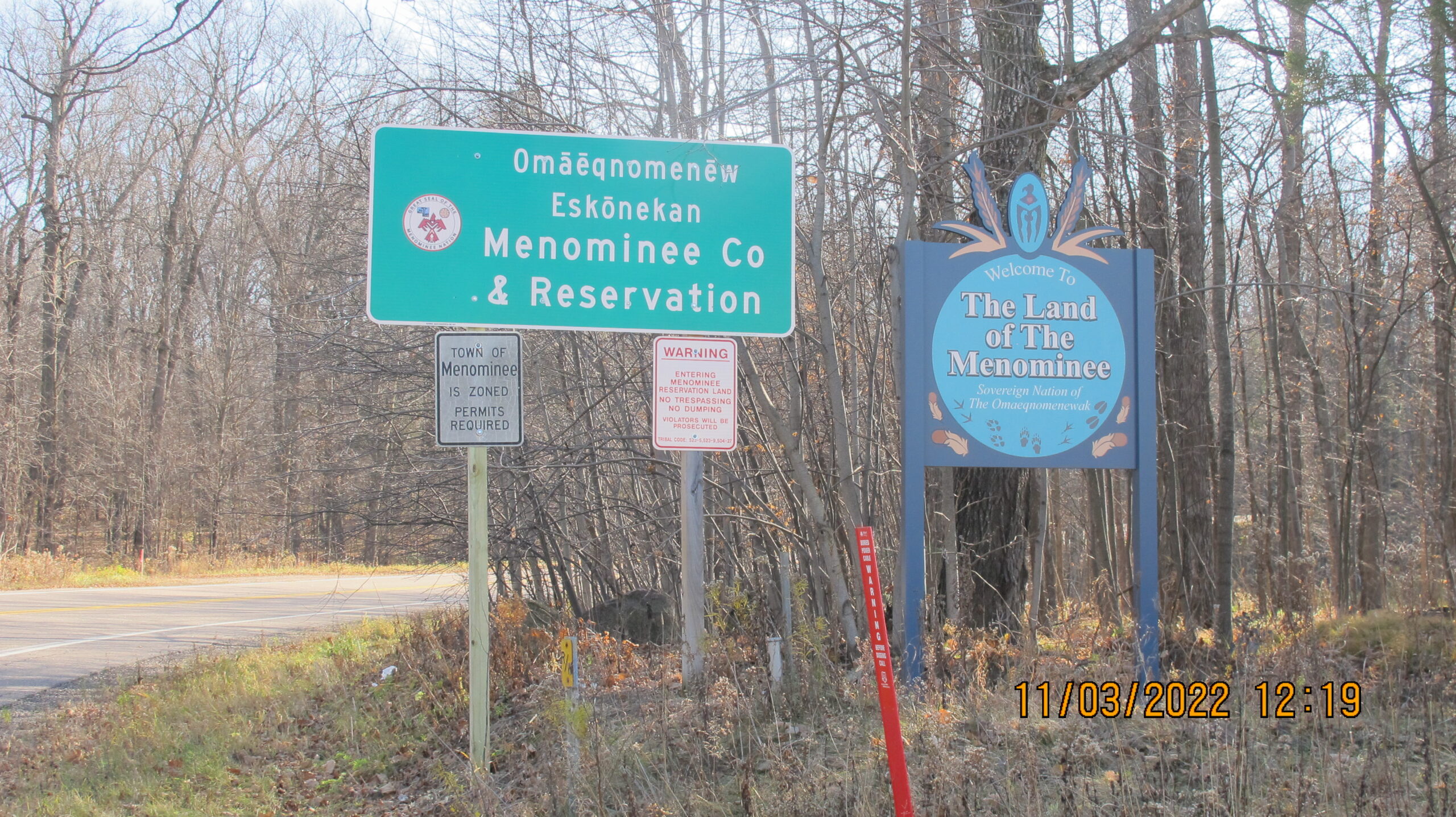 A dual-language highway sign that marks the Menominee Indian Tribe of Wisconsin's reservation boundaries that says, "Welcome to the Land of the Menominee."