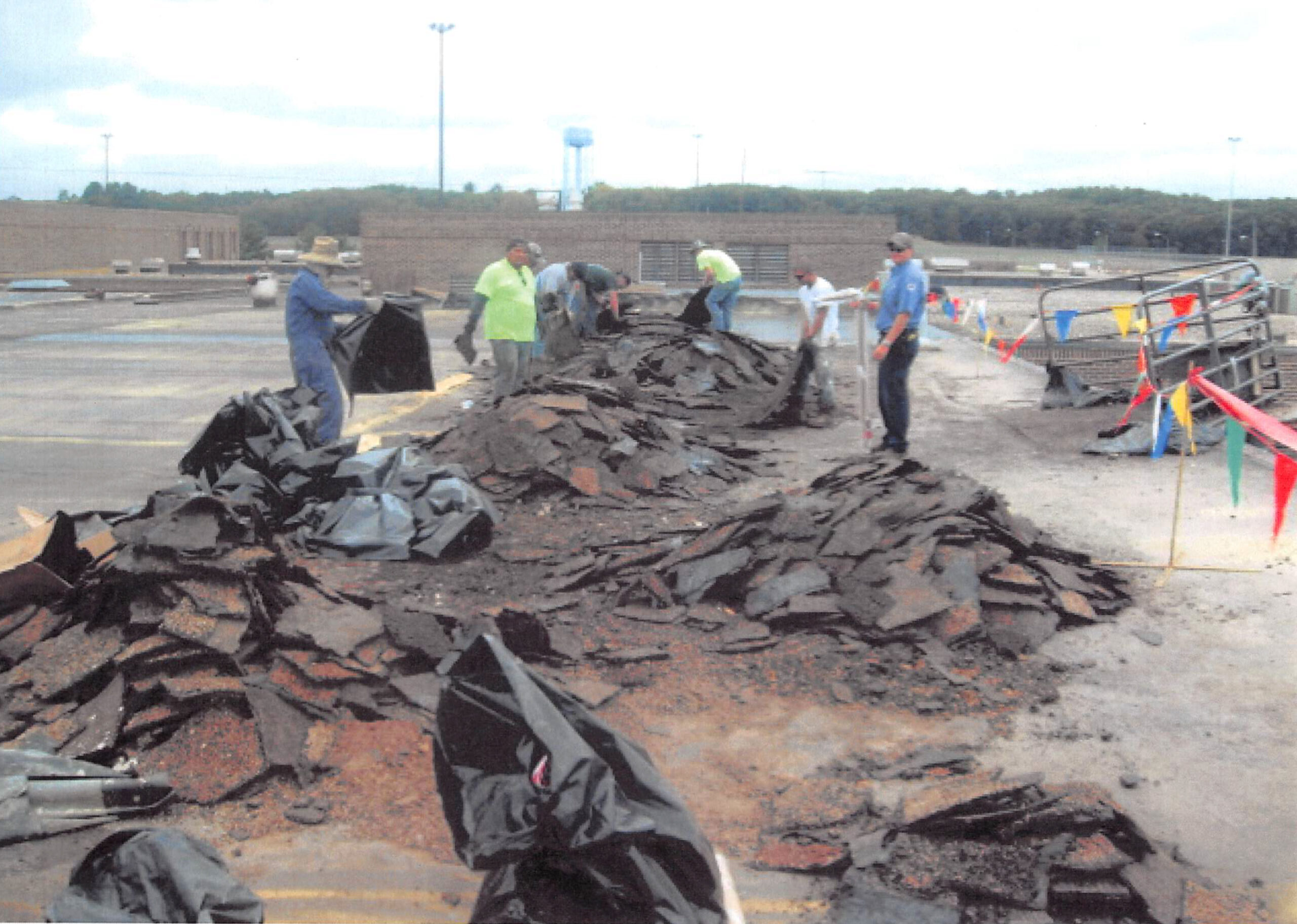 Brazos Urethane, Inc., employees move debris during a 2015 roofing project in Oxford
